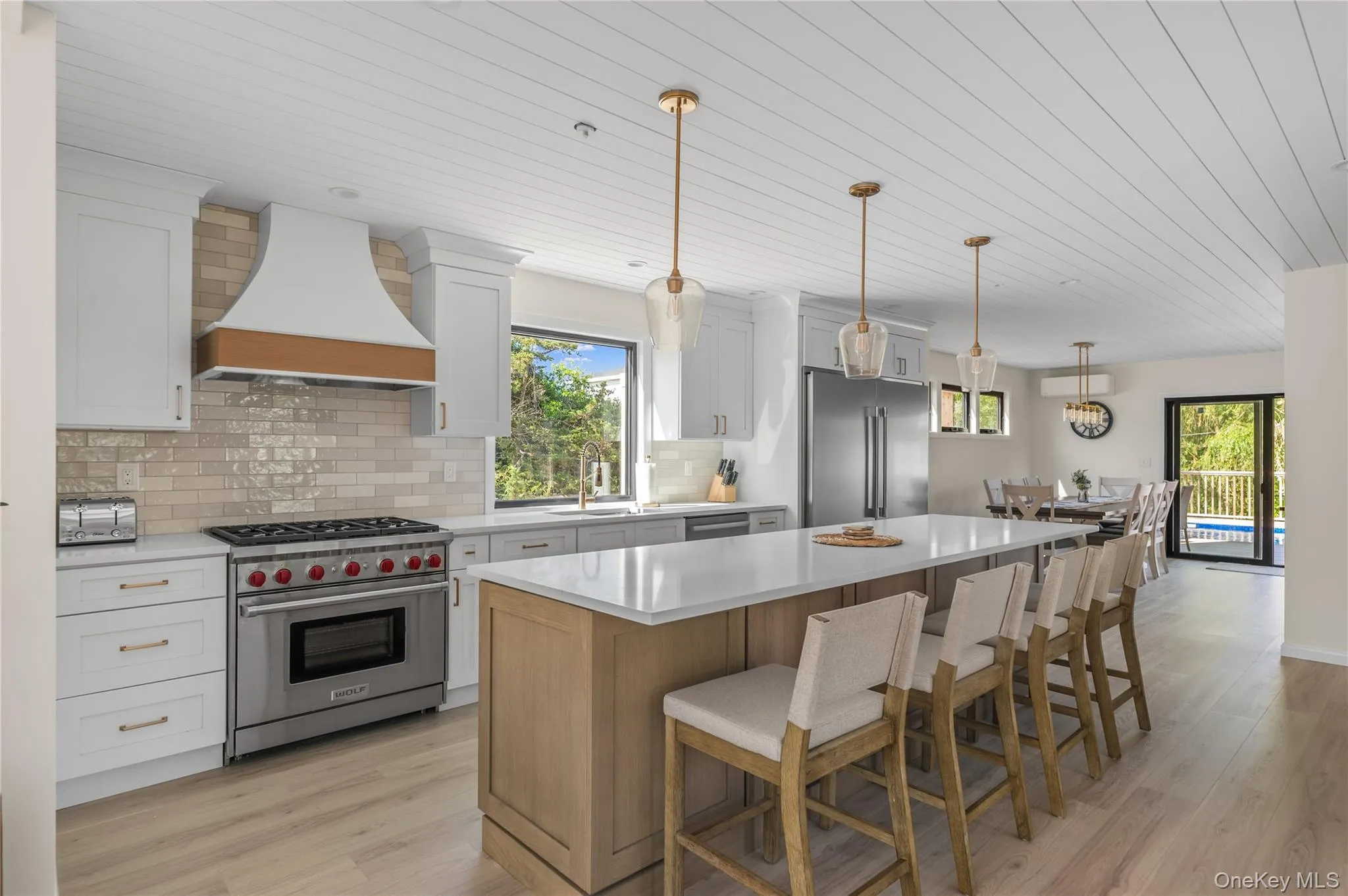 Kitchen with high quality appliances, wooden ceiling, decorative backsplash, a kitchen breakfast bar, and a kitchen island Kitchen with high quality appliances, wooden ceiling, decorative backsplash, a kitchen breakfast bar, and a kitchen island