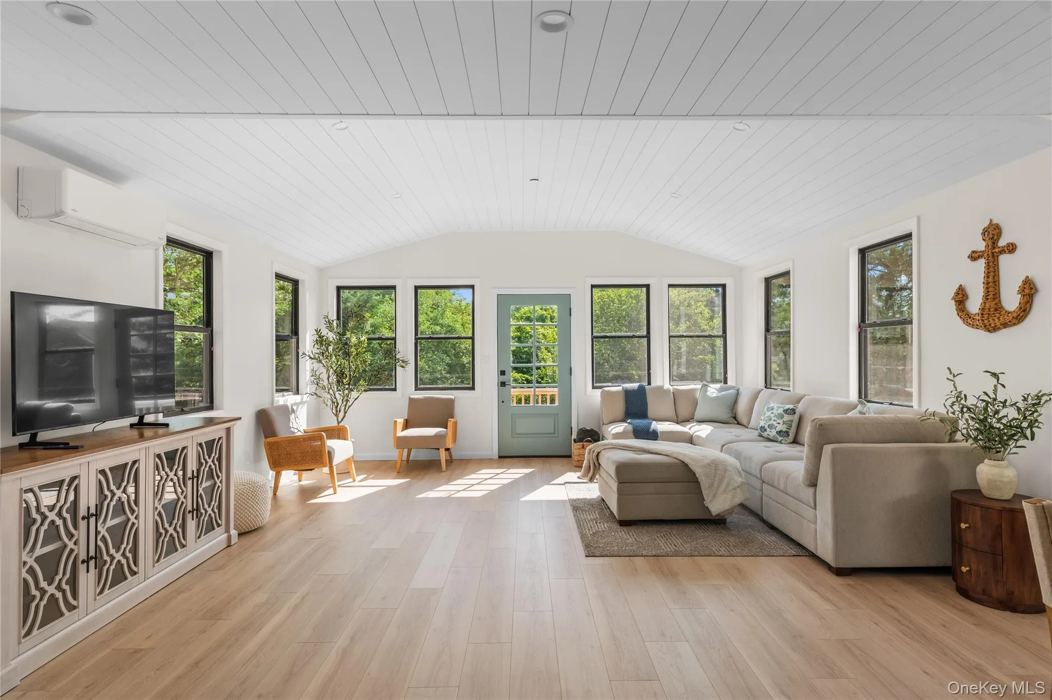 Sunroom with plenty of natural light, a wall unit AC, and lofted ceiling Sunroom with plenty of natural light, a wall unit AC, and lofted ceiling