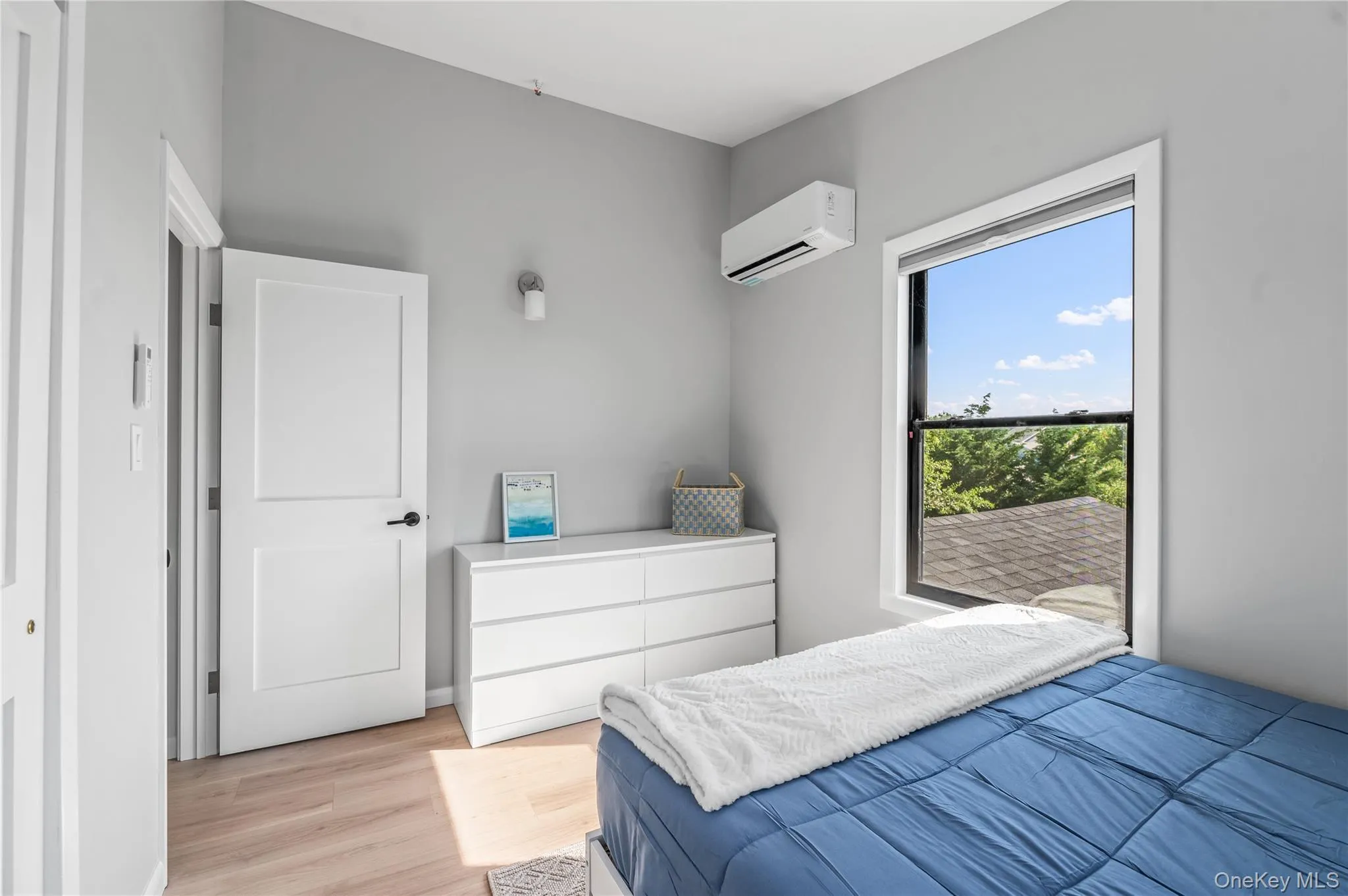 Bedroom with light wood finished floors and a wall mounted AC Bedroom with light wood finished floors and a wall mounted AC