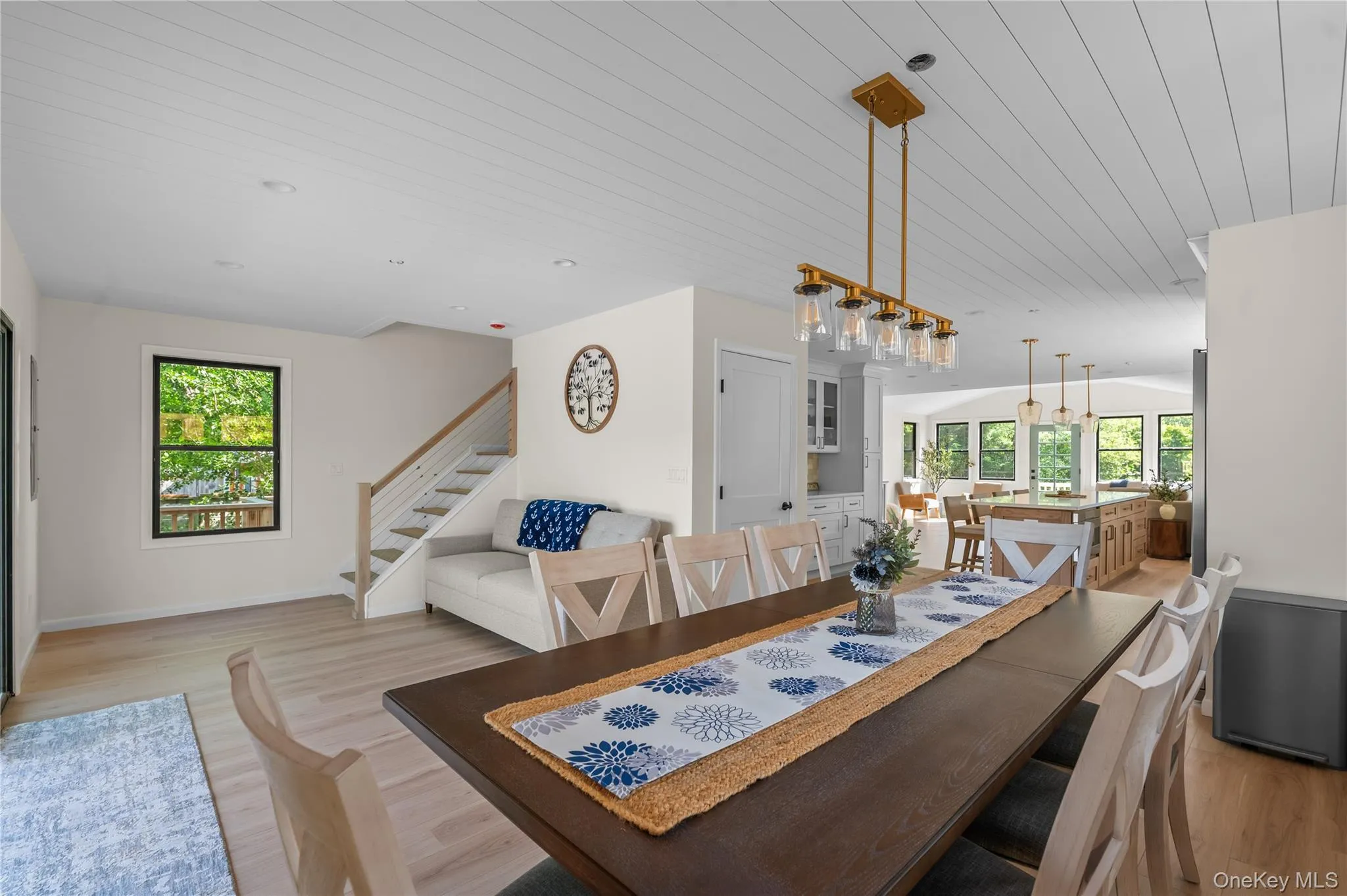 Dining area featuring light wood-style floors, stairs, and wooden ceiling Dining area featuring light wood-style floors, stairs, and wooden ceiling