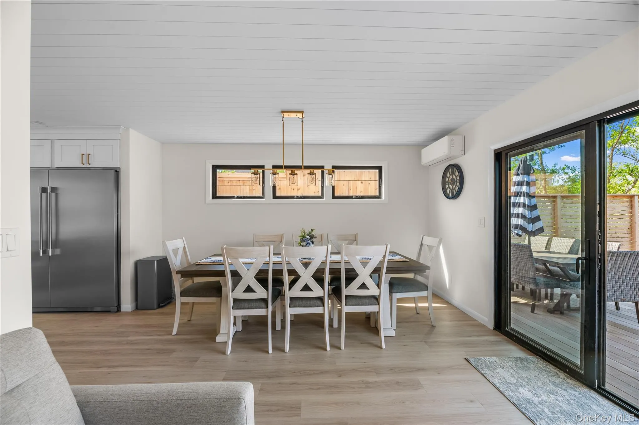 Dining room with light wood-style flooring and an AC wall unit Dining room with light wood-style flooring and an AC wall unit
