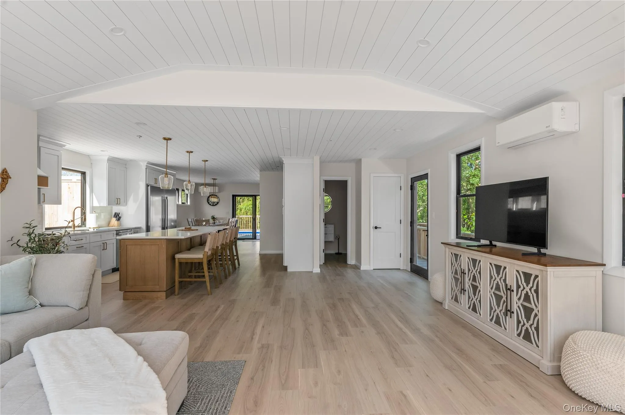 Living area featuring wooden ceiling, an AC wall unit, light wood finished floors, and lofted ceiling Living area featuring wooden ceiling, an AC wall unit, light wood finished floors, and lofted ceiling