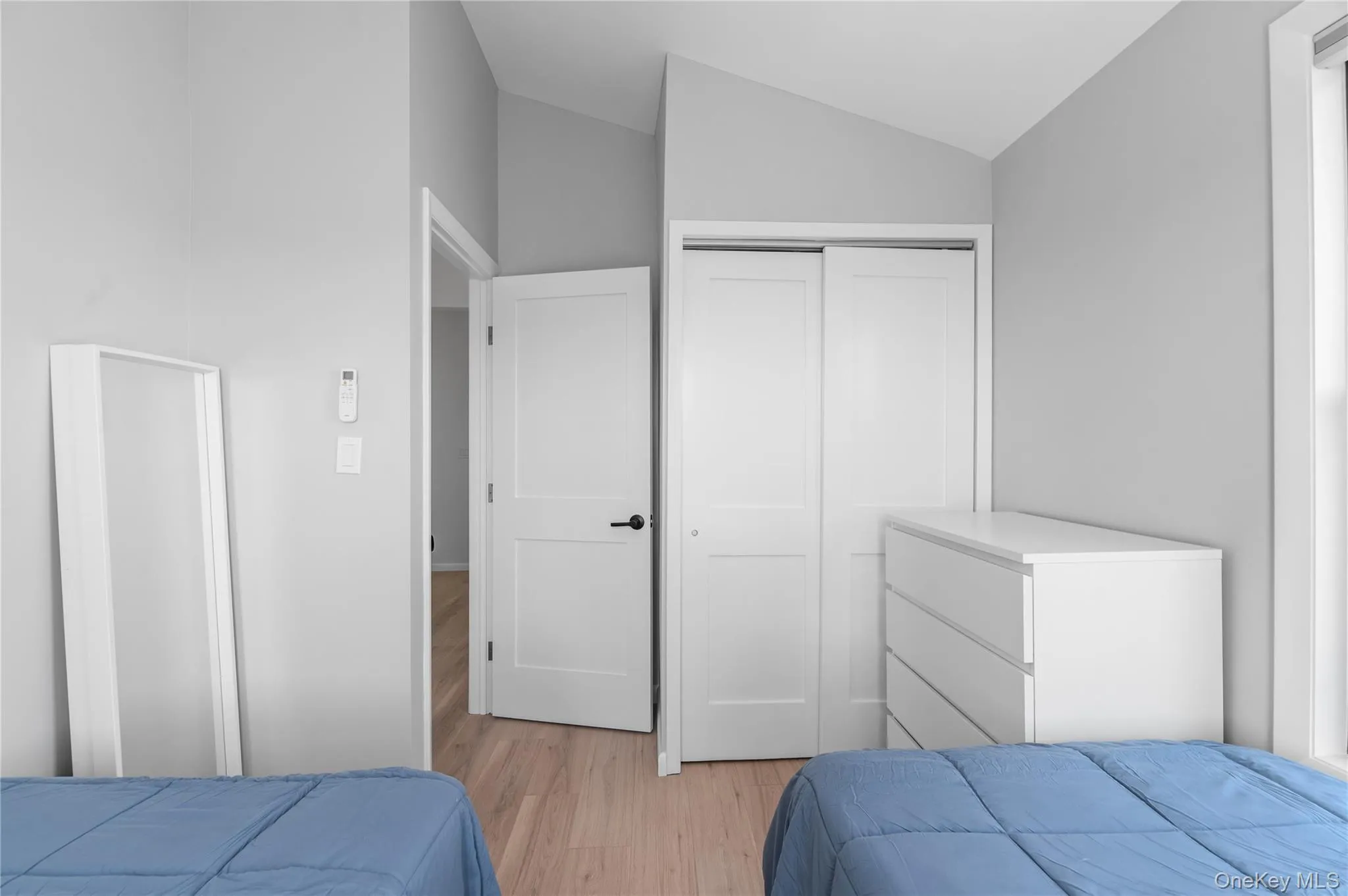 Bedroom featuring light wood-type flooring, a closet, and lofted ceiling Bedroom featuring light wood-type flooring, a closet, and lofted ceiling