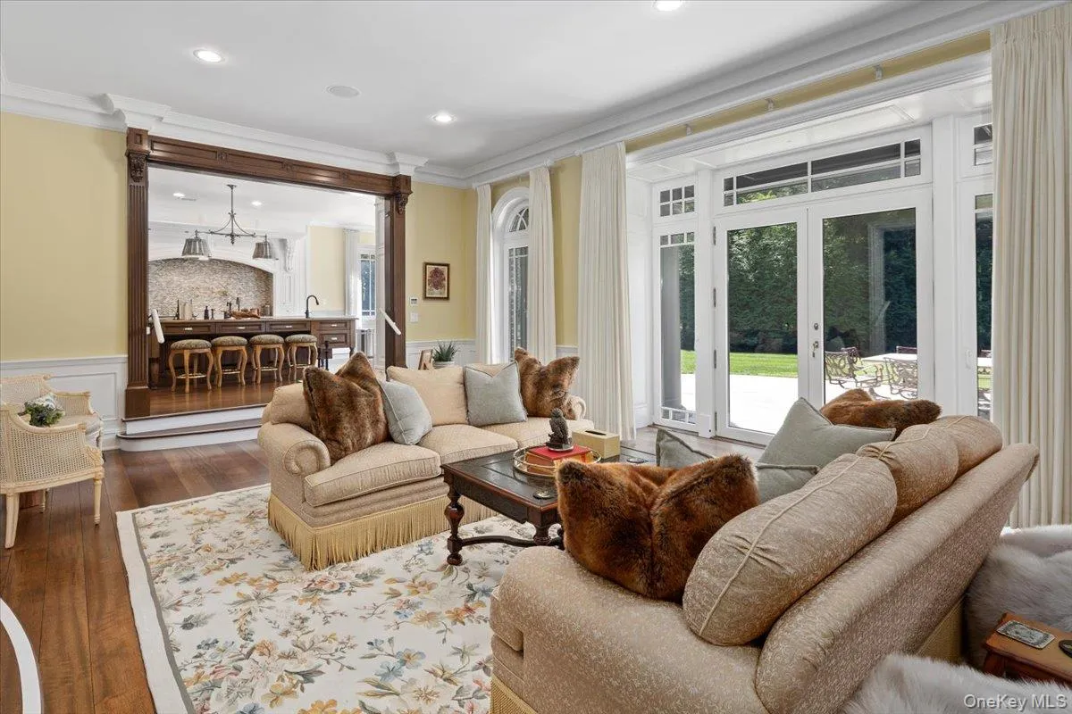 Living area with a wainscoted wall, dark wood-type flooring, ornamental molding, french doors, and recessed lighting Living area with a wainscoted wall, dark wood-type flooring, ornamental molding, french doors, and recessed lighting