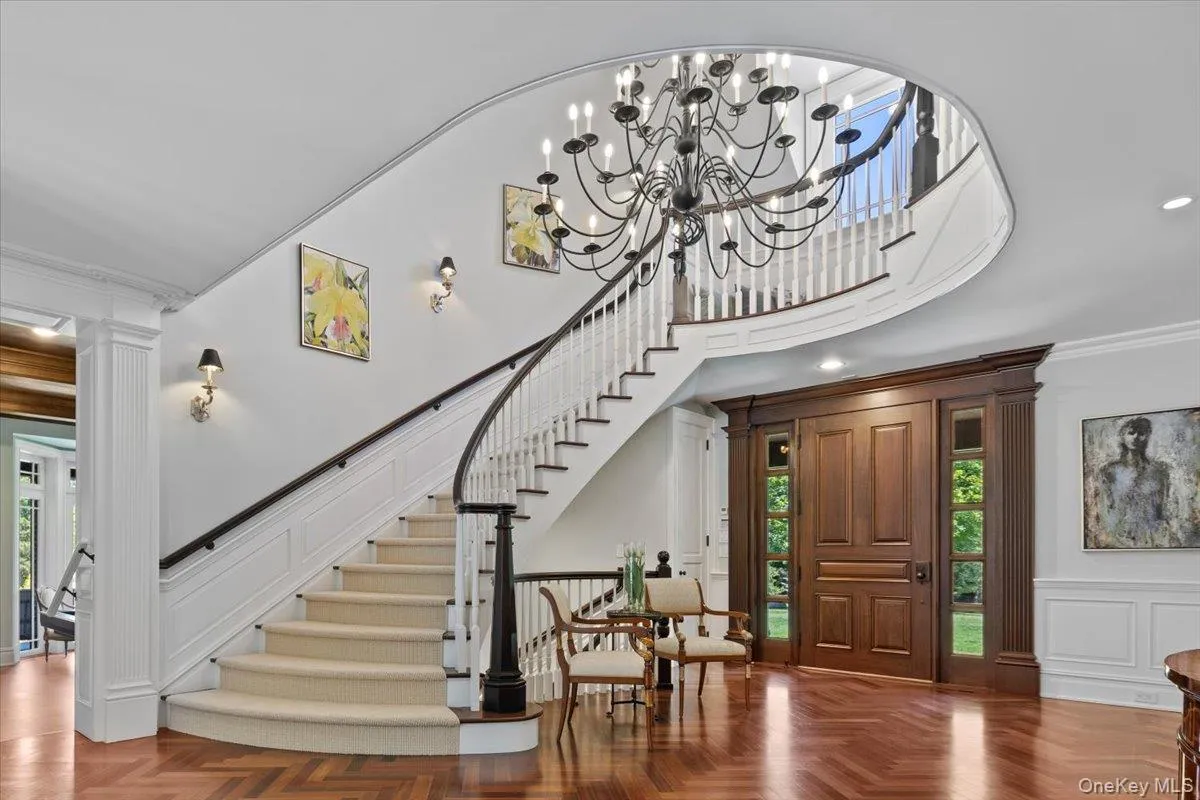 Entrance foyer with healthy amount of natural light, a decorative wall, decorative columns, crown molding, and stairs Entrance foyer with healthy amount of natural light, a decorative wall, decorative columns, crown molding, and stairs