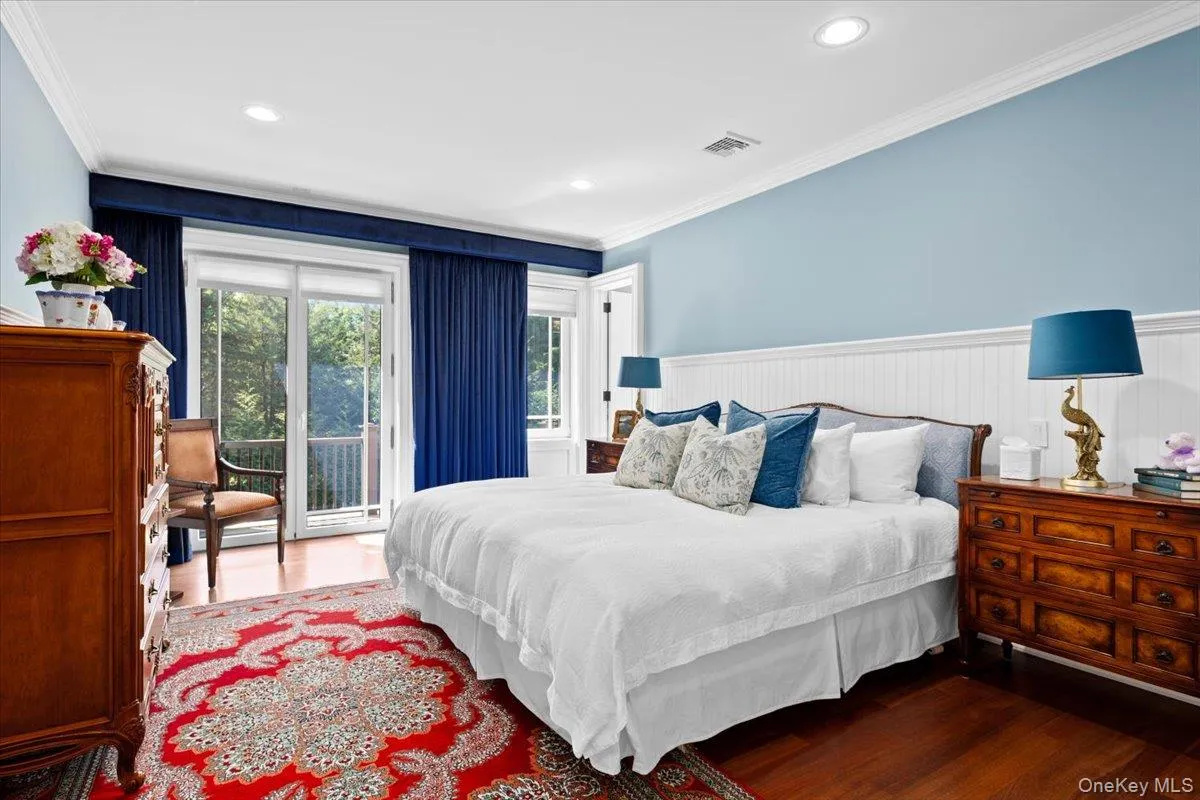 Bedroom featuring ornamental molding, wood finished floors, access to exterior, wainscoting, and recessed lighting Bedroom featuring ornamental molding, wood finished floors, access to exterior, wainscoting, and recessed lighting