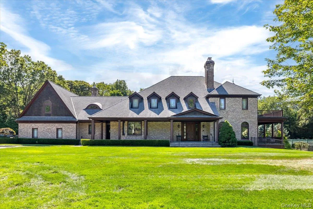 View of front of property featuring a chimney, a front lawn, and brick siding View of front of property featuring a chimney, a front lawn, and brick siding