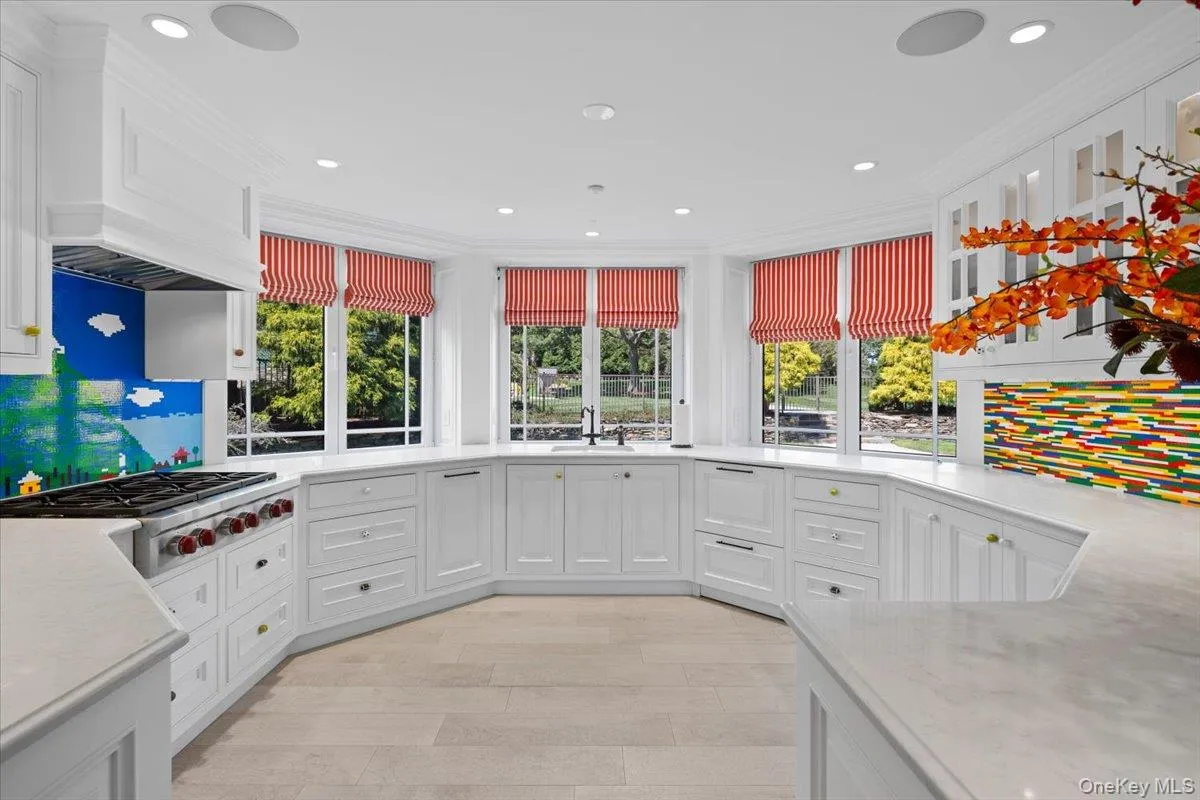 Kitchen with white cabinetry, stainless steel gas stovetop, recessed lighting, light stone countertops, and light wood-type flooring Kitchen with white cabinetry, stainless steel gas stovetop, recessed lighting, light stone countertops, and light wood-type flooring