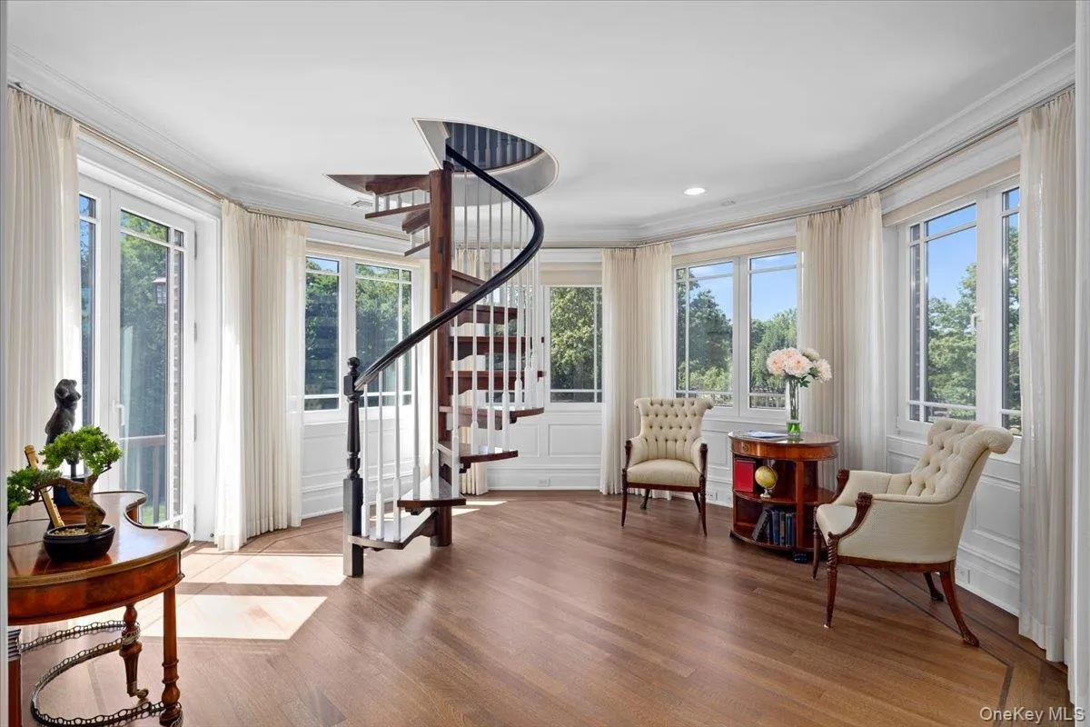 Sitting room with crown molding, light wood-style flooring, and stairs Sitting room with crown molding, light wood-style flooring, and stairs