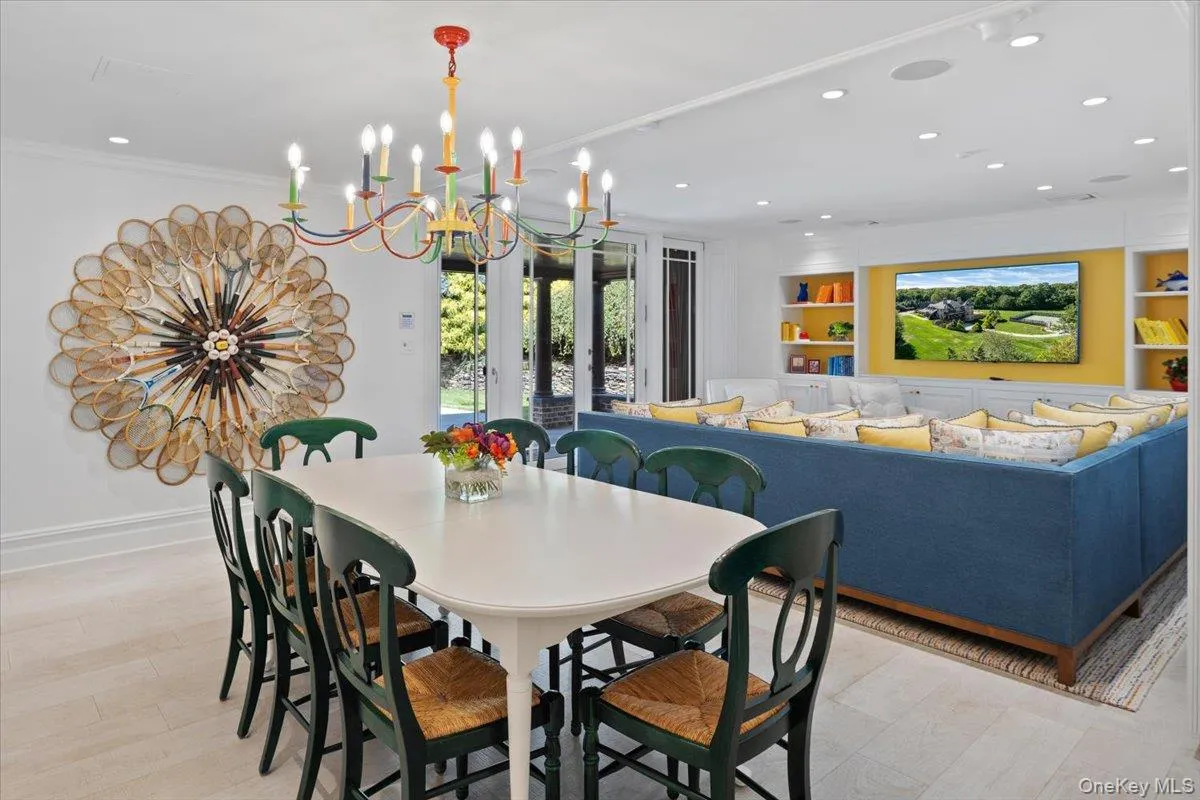 Dining room featuring a chandelier, light wood-style floors, built in shelves, recessed lighting, and ornamental molding Dining room featuring a chandelier, light wood-style floors, built in shelves, recessed lighting, and ornamental molding