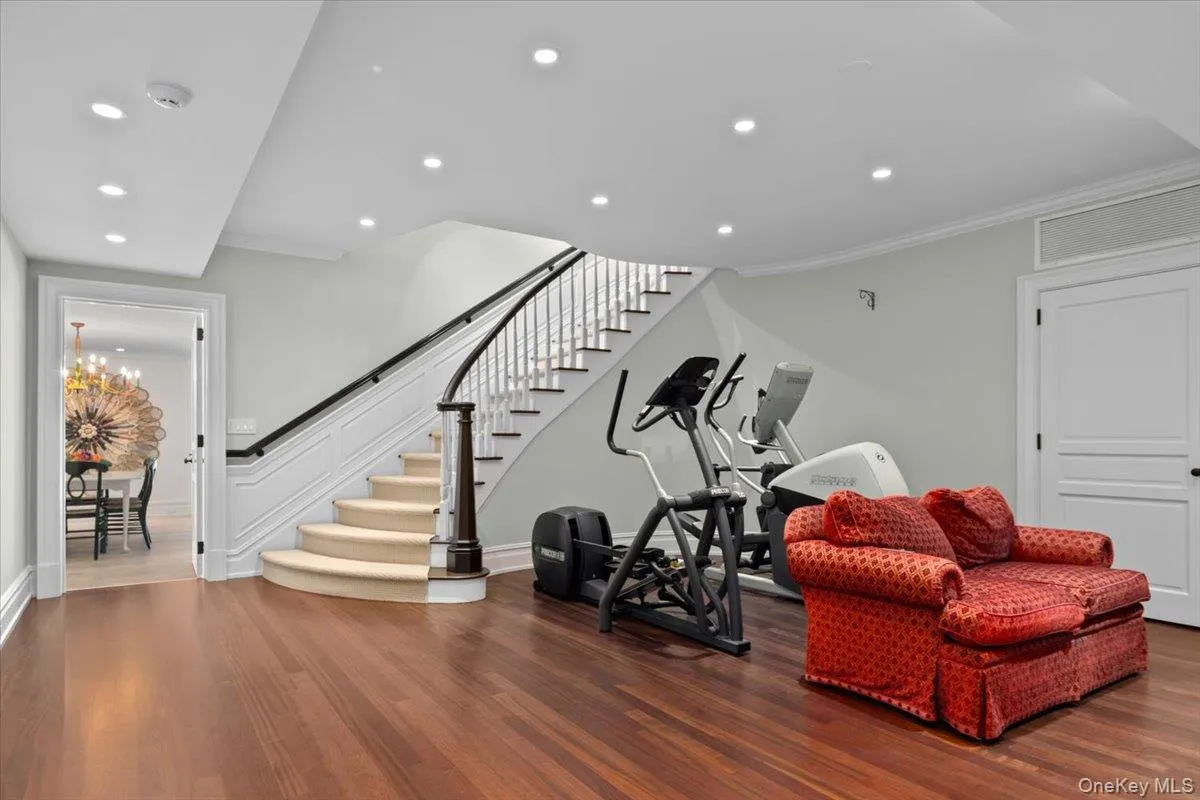 Workout room featuring wood finished floors, crown molding, a chandelier, and recessed lighting Workout room featuring wood finished floors, crown molding, a chandelier, and recessed lighting