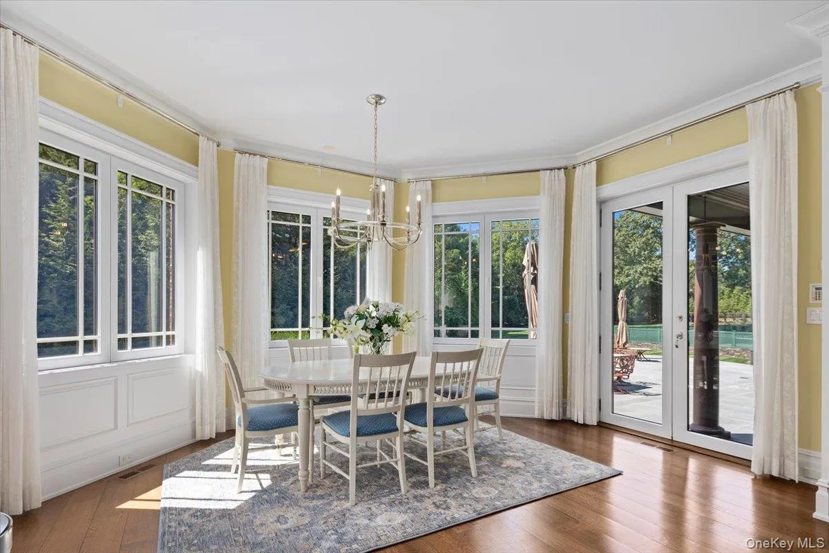 Dining area with healthy amount of natural light, dark wood-style floors, a chandelier, and ornamental molding Dining area with healthy amount of natural light, dark wood-style floors, a chandelier, and ornamental molding