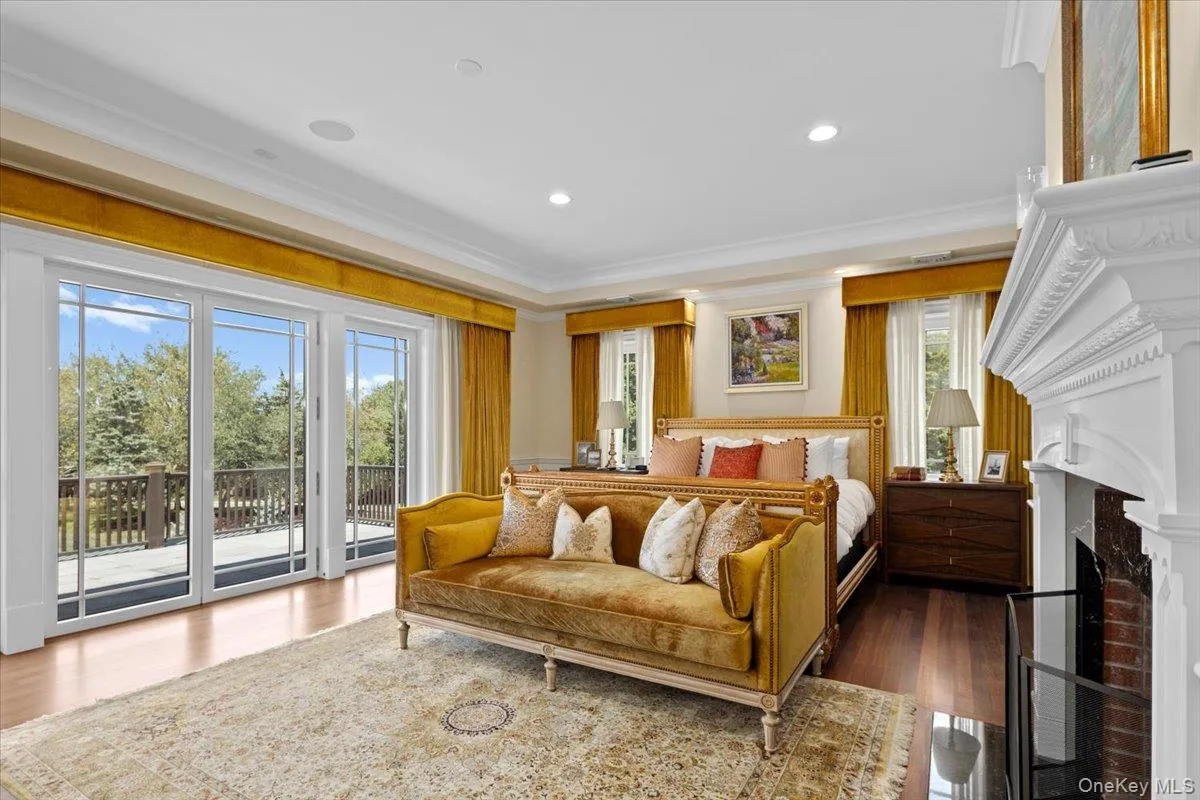 Bedroom with wood finished floors, access to outside, recessed lighting, a fireplace, and ornamental molding Bedroom with wood finished floors, access to outside, recessed lighting, a fireplace, and ornamental molding