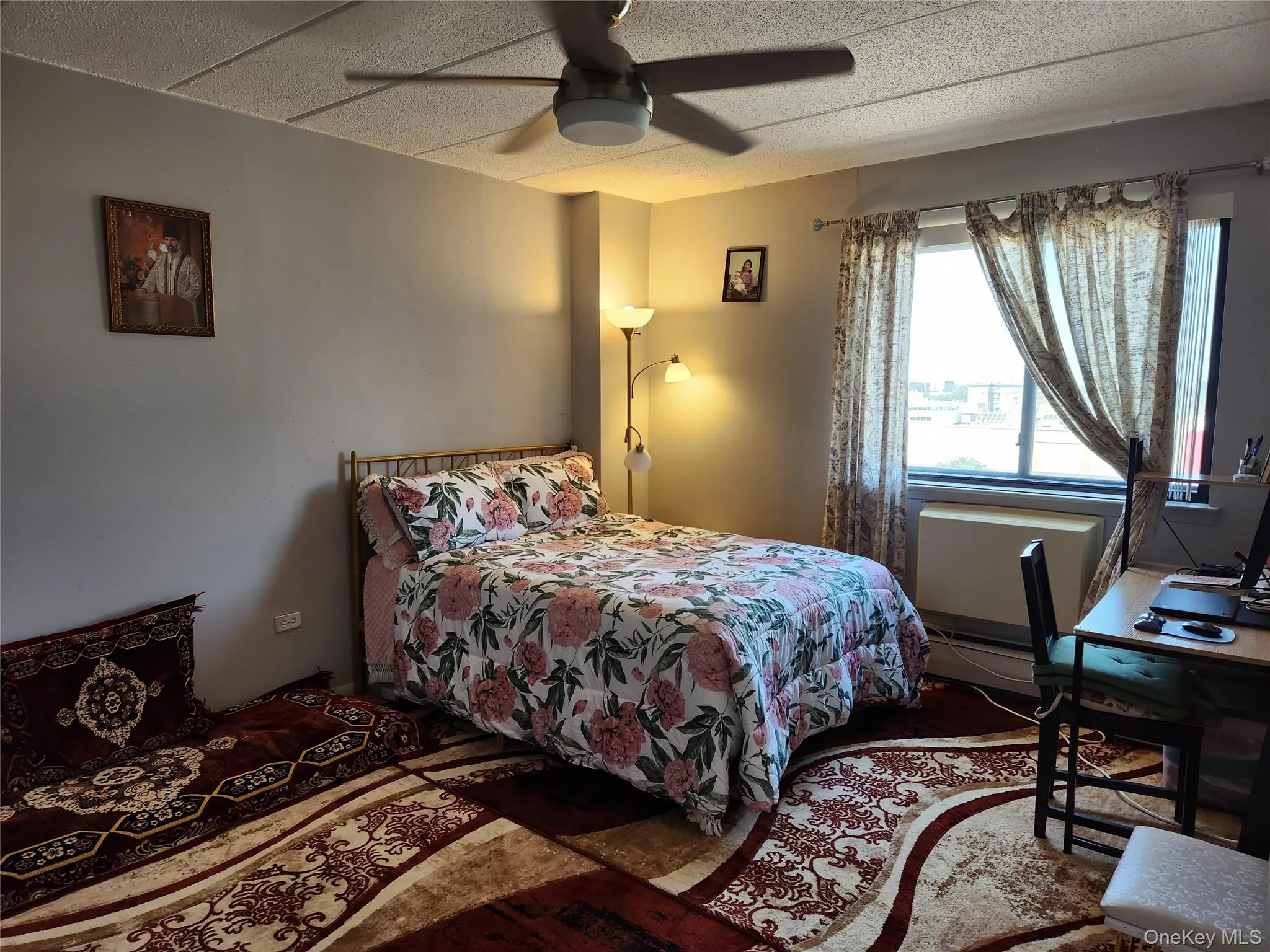 Bedroom with a ceiling fan, a desk, and a baseboard radiator Bedroom with a ceiling fan, a desk, and a baseboard radiator