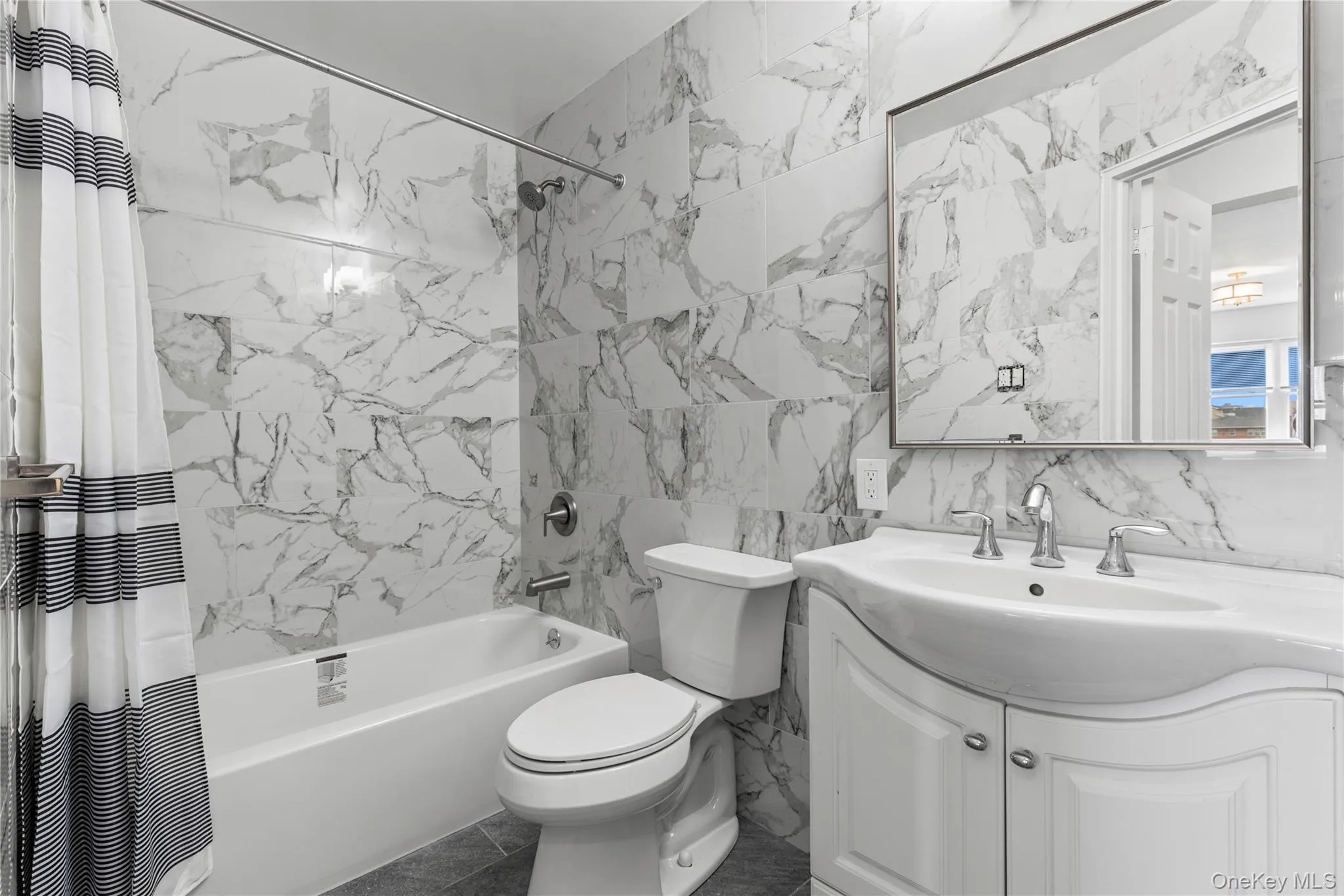 Bathroom with tile walls, shower / bathtub combination with curtain, and vanity Bathroom with tile walls, shower / bathtub combination with curtain, and vanity