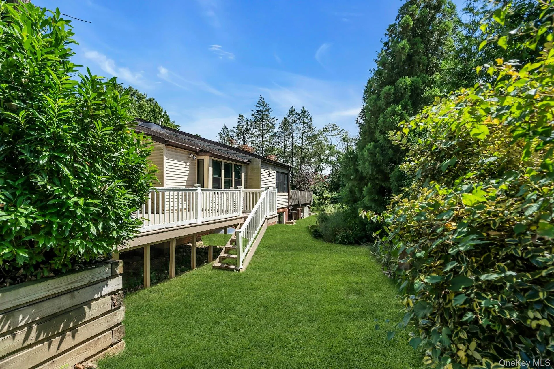 View of green lawn with a deck and stairway View of green lawn with a deck and stairway