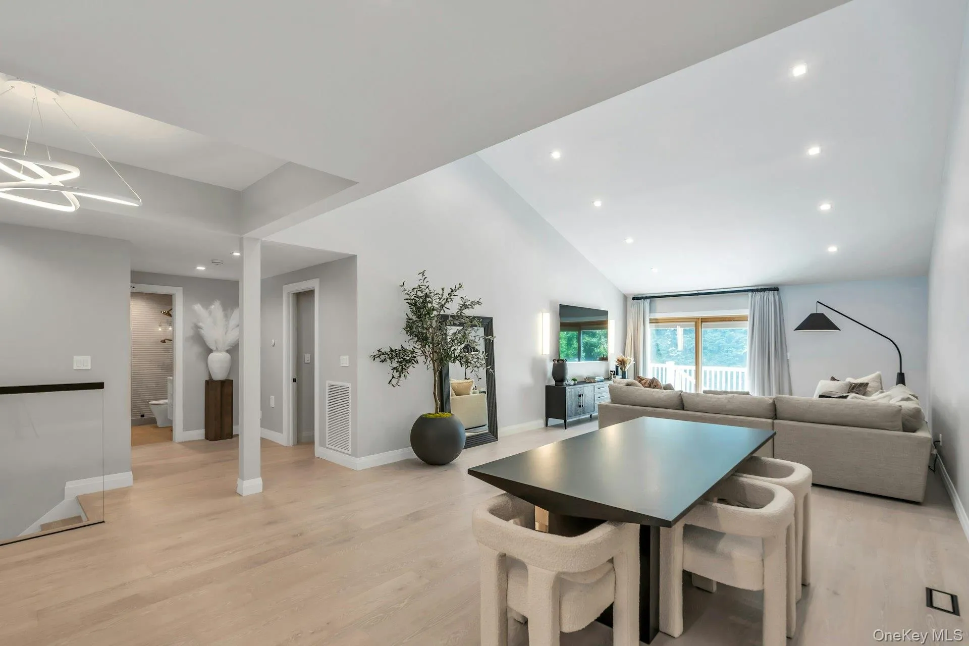 Dining space featuring light wood-style floors, recessed lighting, lofted ceiling, and a chandelier Dining space featuring light wood-style floors, recessed lighting, lofted ceiling, and a chandelier