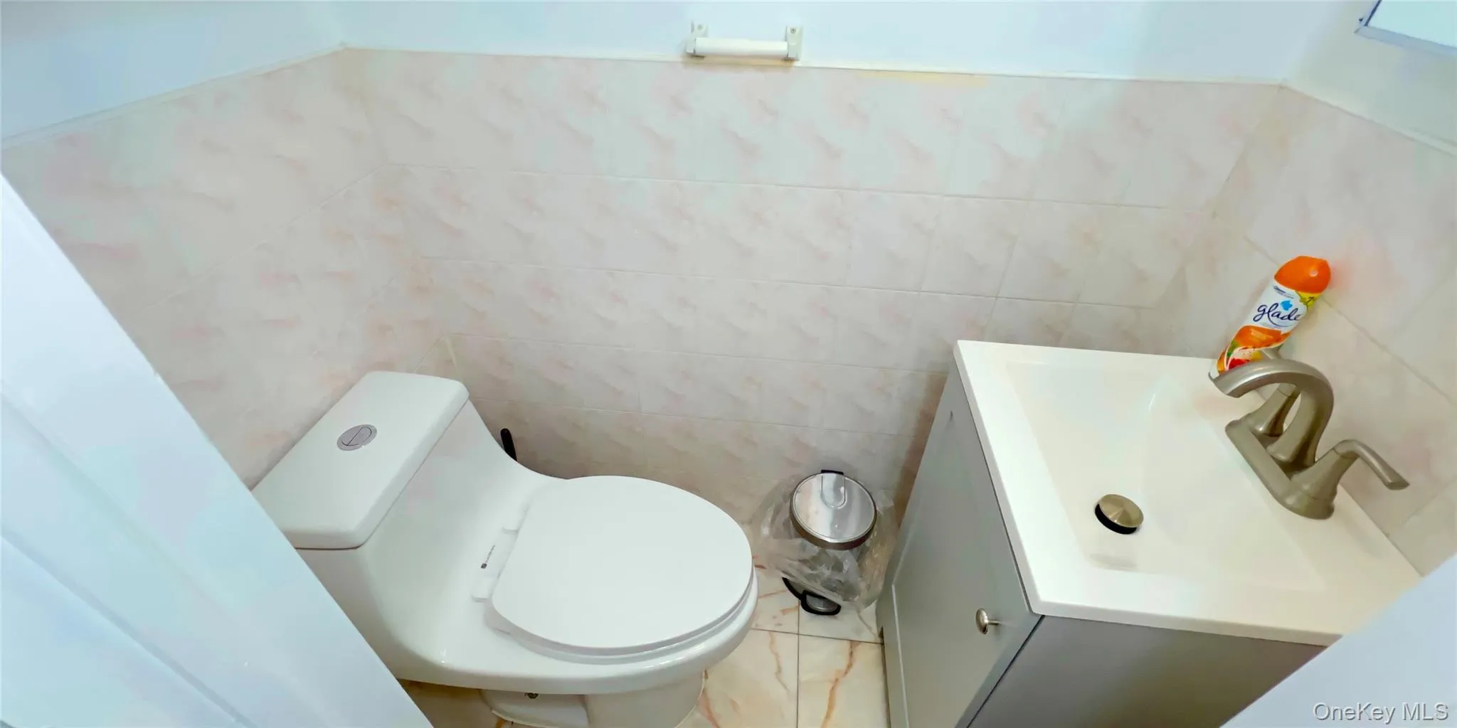 Half bathroom with vanity and tile walls Half bathroom with vanity and tile walls