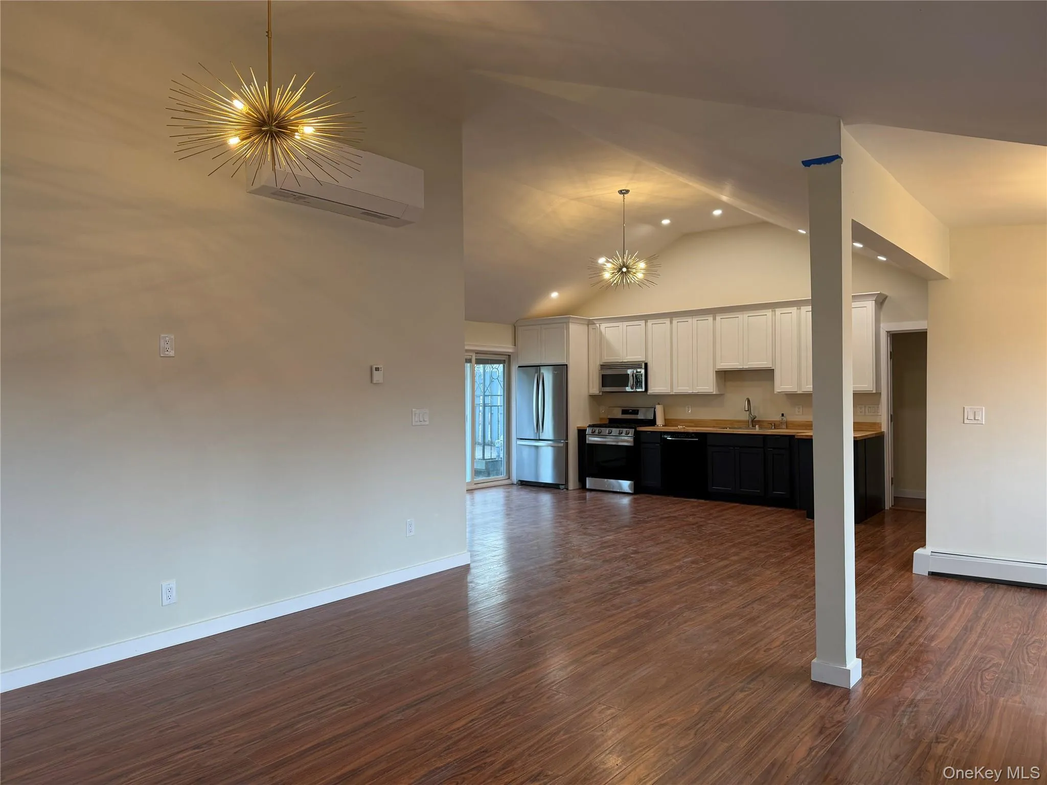 Unfurnished living room with a chandelier, dark wood-style floors, a wall unit AC, recessed lighting, and high vaulted ceiling Unfurnished living room with a chandelier, dark wood-style floors, a wall unit AC, recessed lighting, and high vaulted ceiling