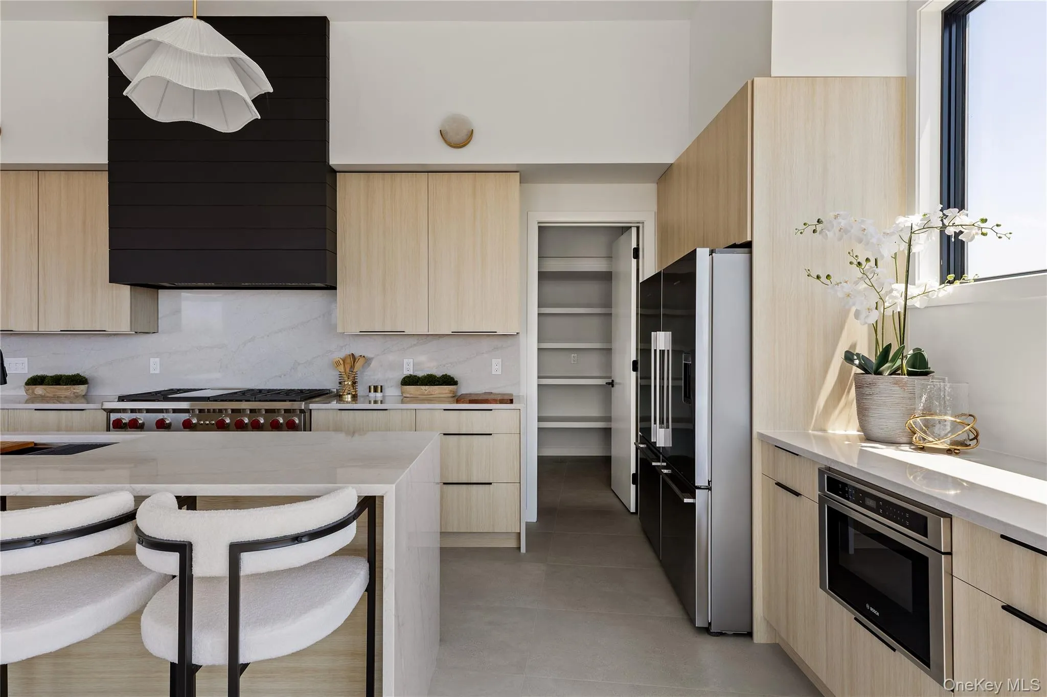 Kitchen featuring light brown cabinets, light stone counters, modern cabinets, and high quality fridge Kitchen featuring light brown cabinets, light stone counters, modern cabinets, and high quality fridge