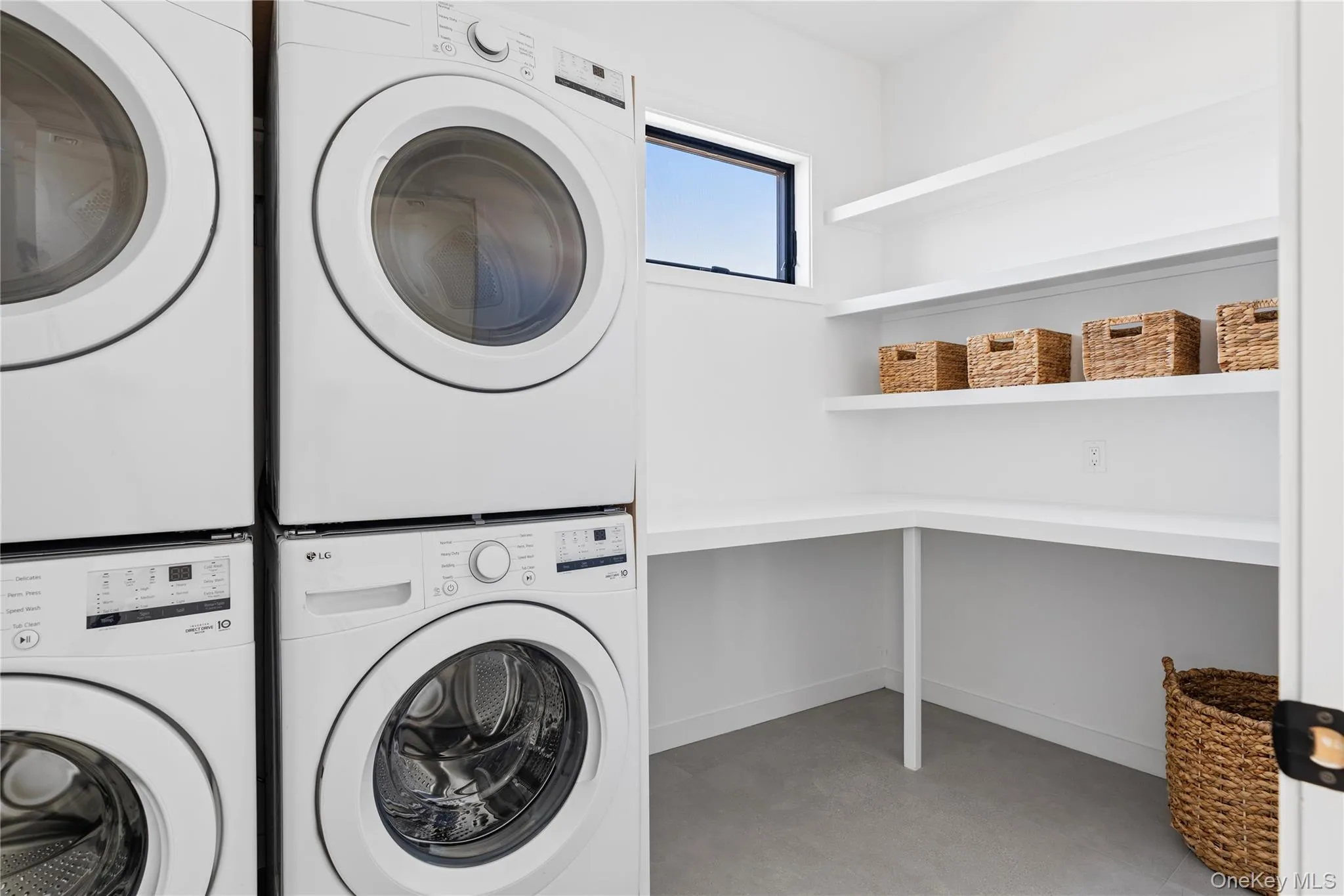 Washroom with stacked washer and clothes dryer and baseboards Washroom with stacked washer and clothes dryer and baseboards