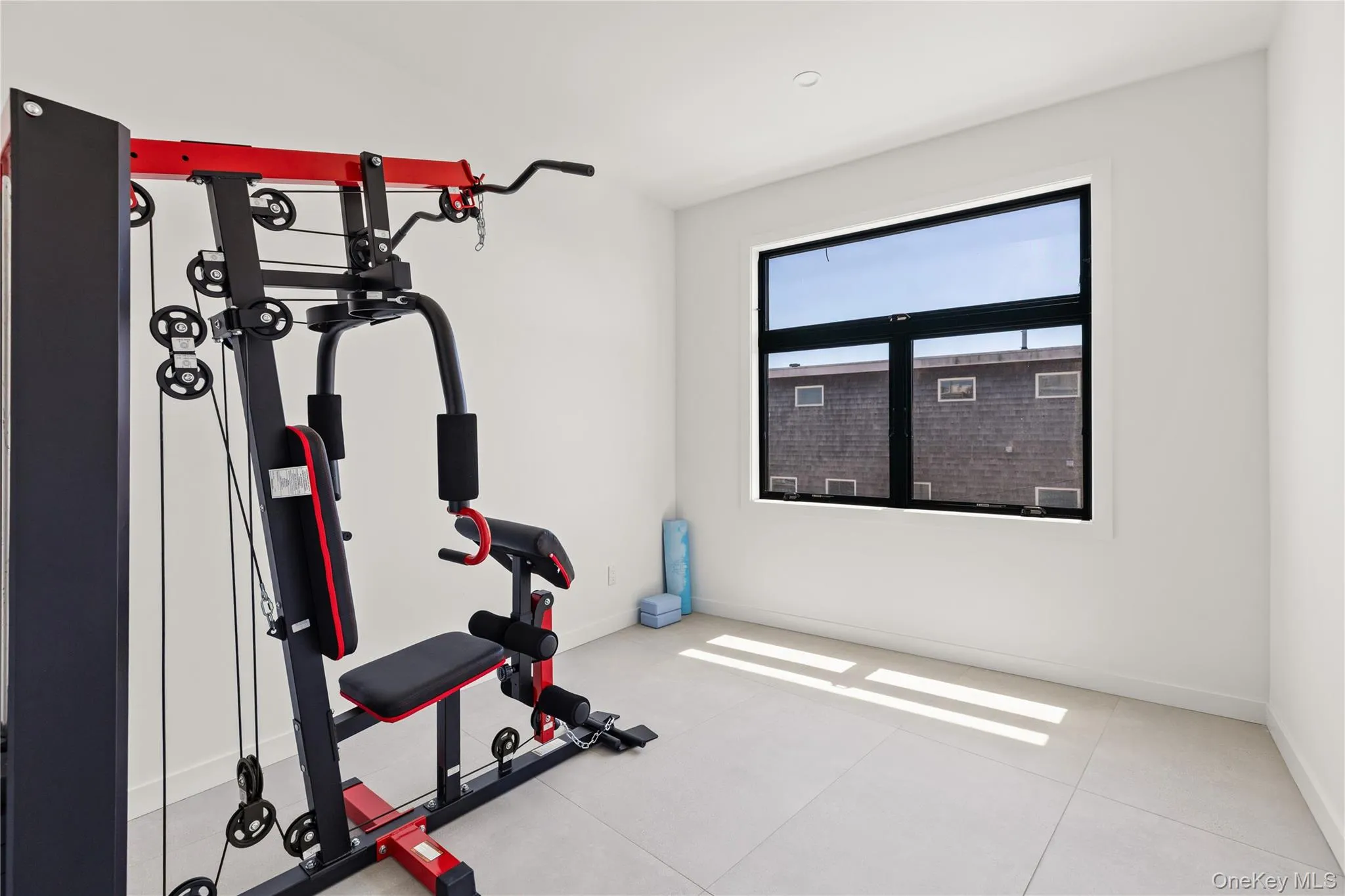 Workout area with baseboards and light tile patterned floors Workout area with baseboards and light tile patterned floors