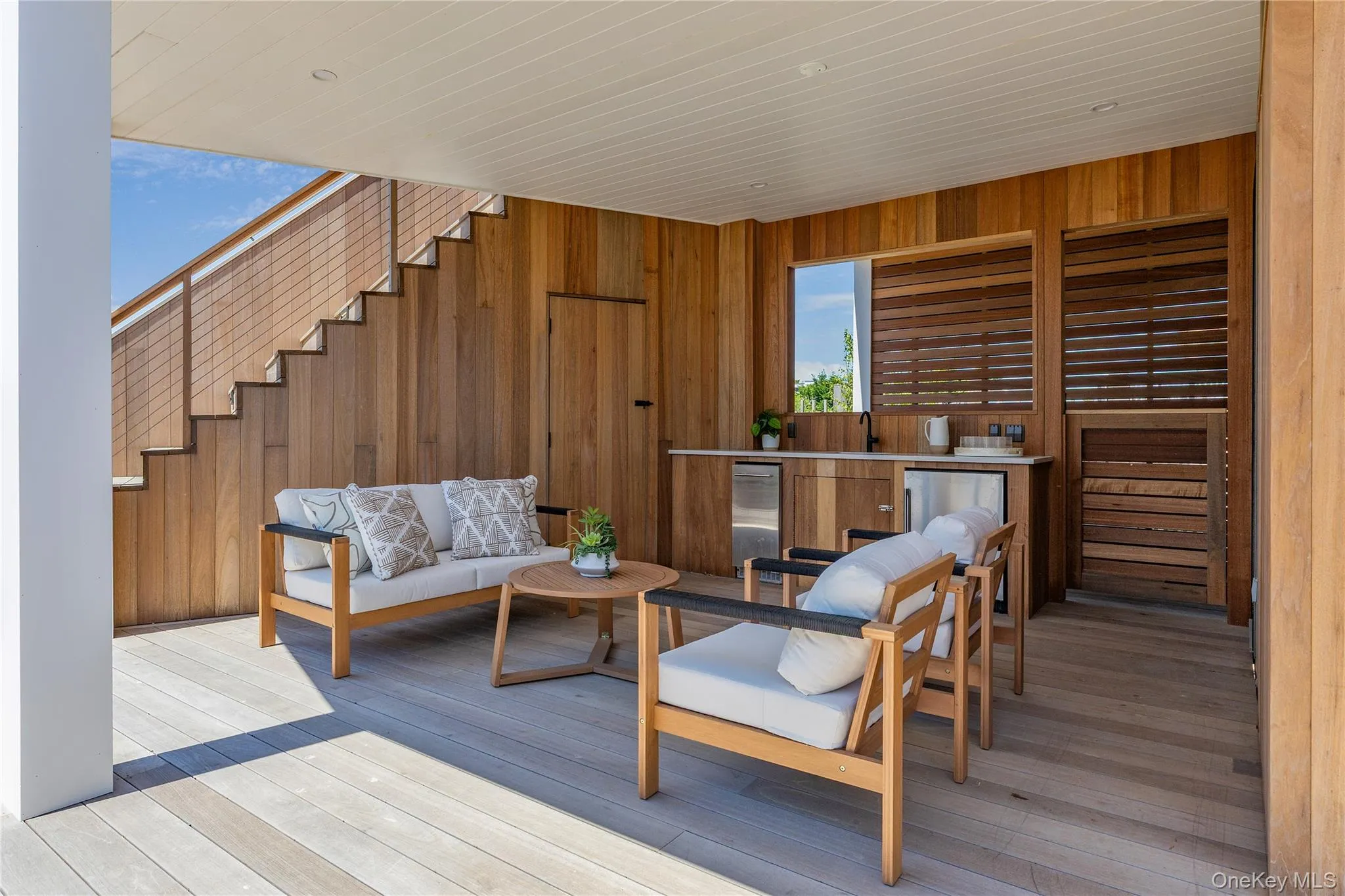 Living area featuring wooden walls, light wood-type flooring, and wooden ceiling Living area featuring wooden walls, light wood-type flooring, and wooden ceiling