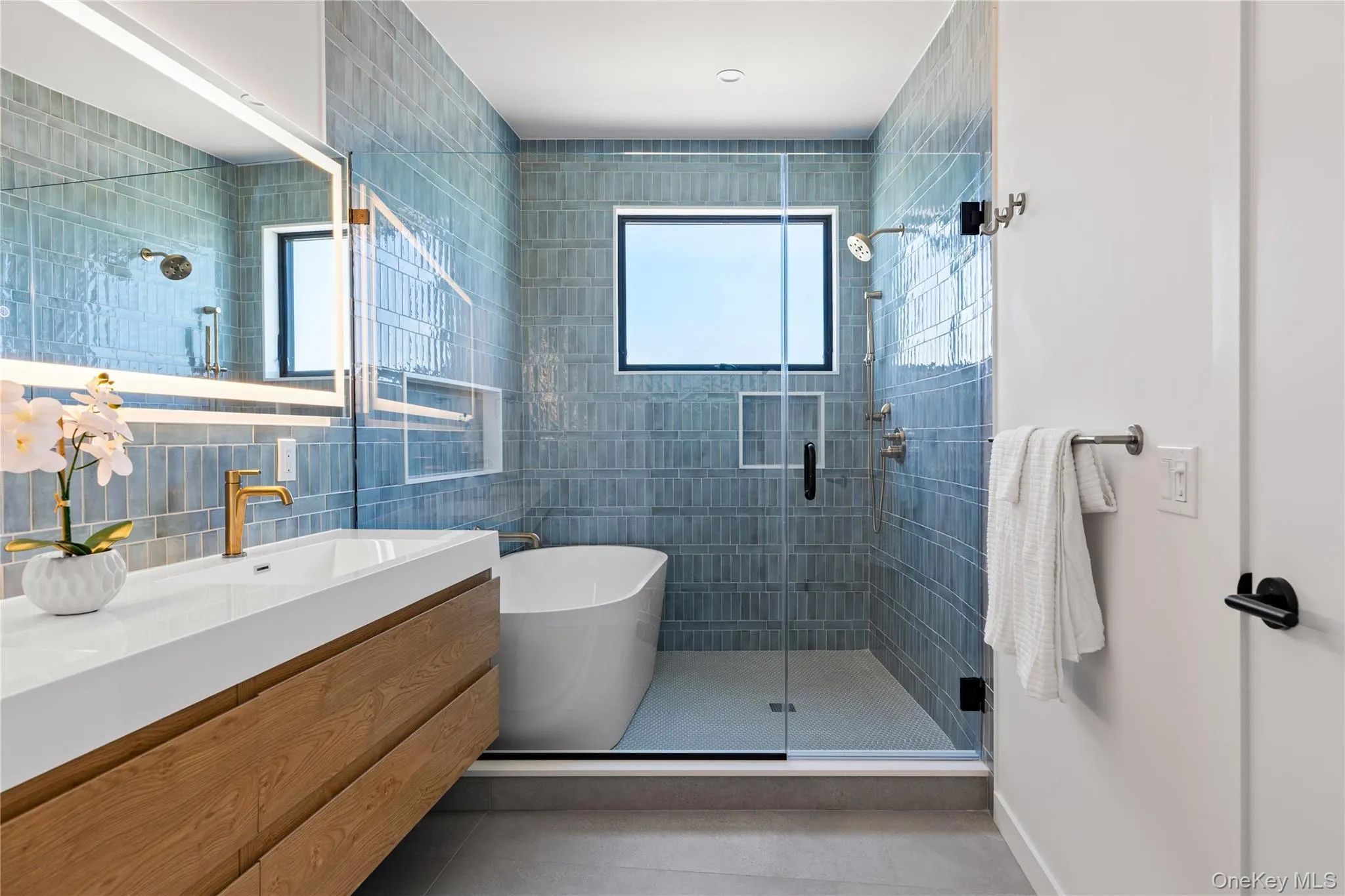 Full bath featuring a shower stall, tile walls, vanity, a soaking tub, and light tile patterned flooring Full bath featuring a shower stall, tile walls, vanity, a soaking tub, and light tile patterned flooring