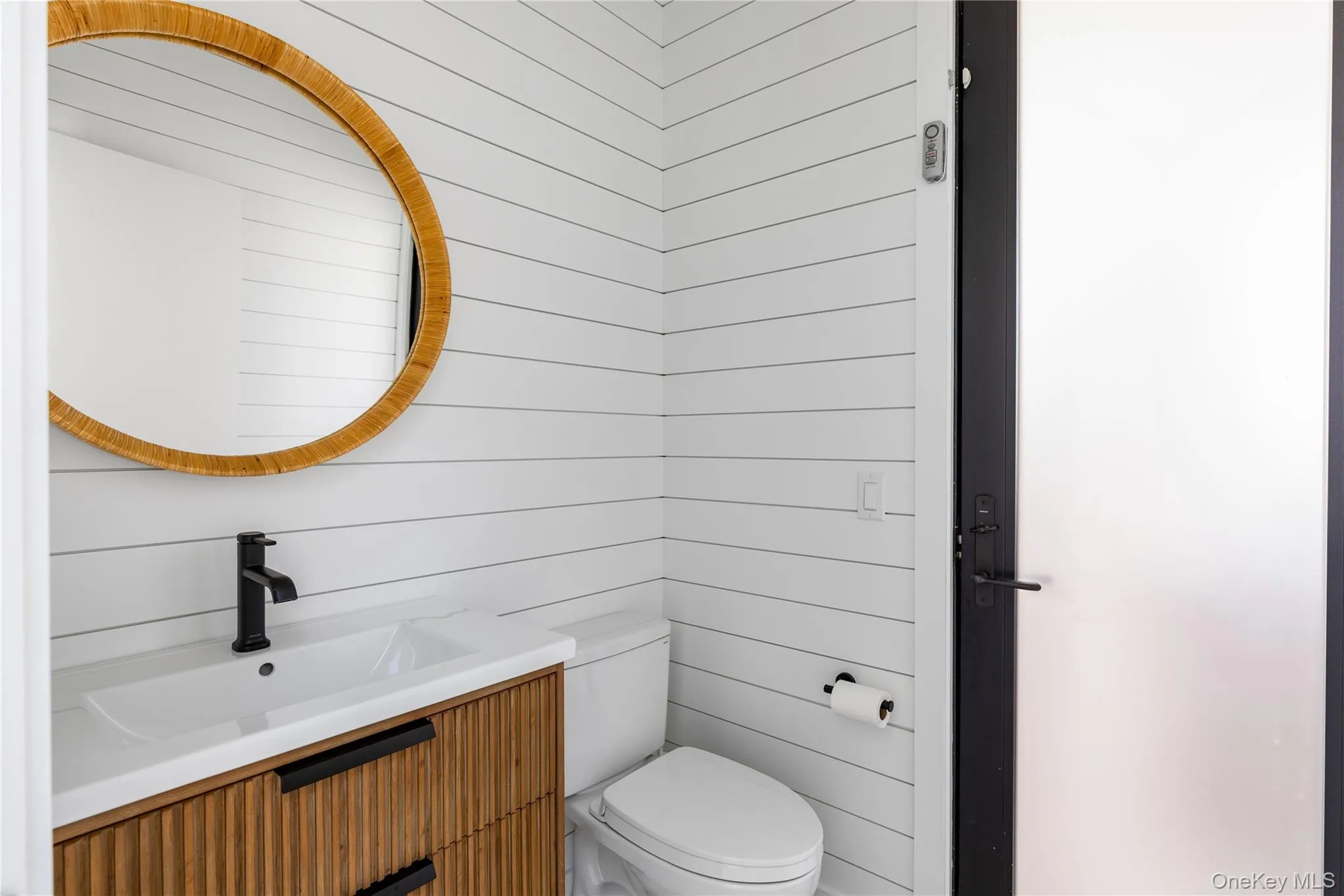 Half bathroom featuring vanity and wood walls Half bathroom featuring vanity and wood walls