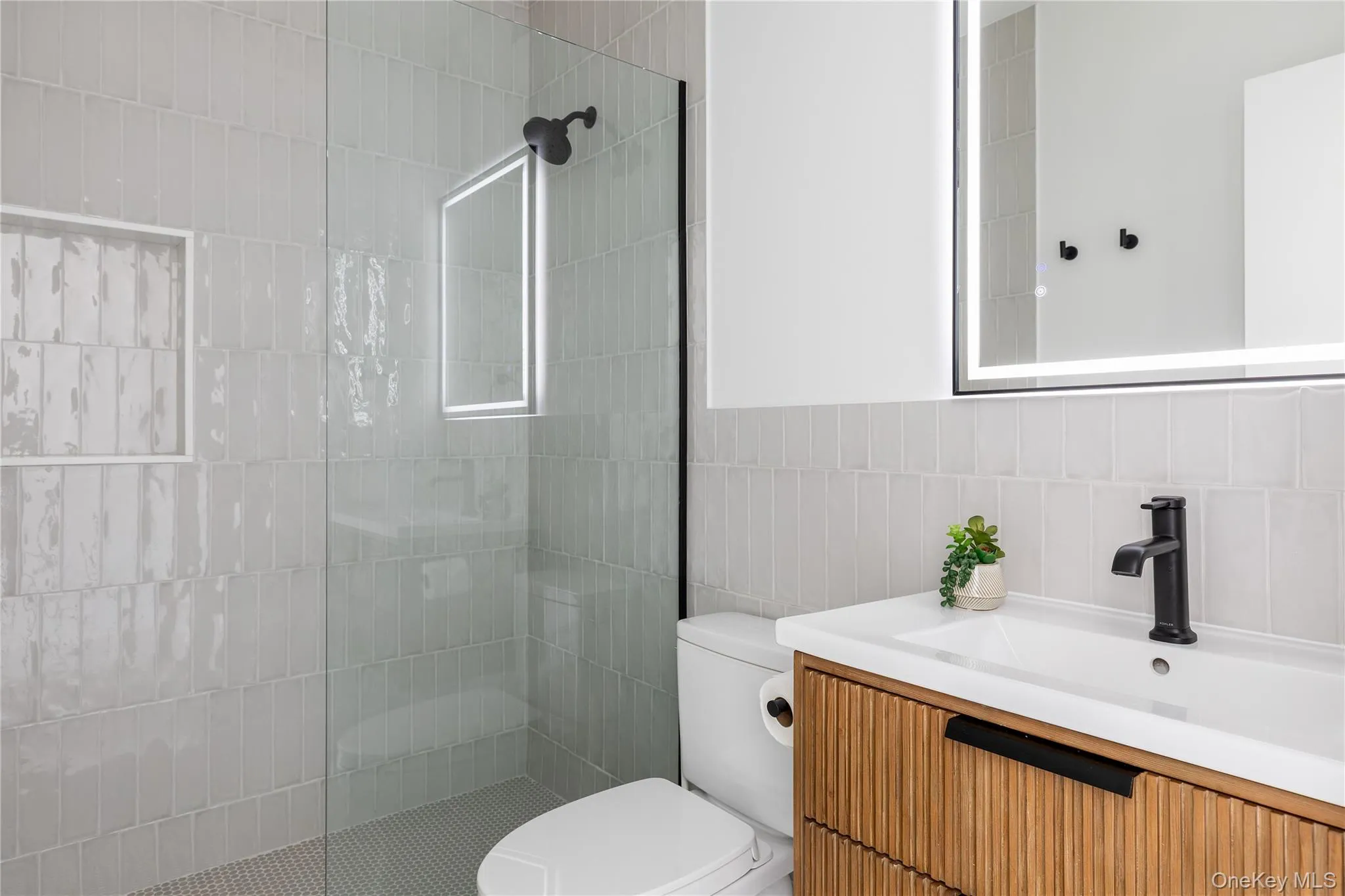 Full bath with vanity, a walk in shower, and tile walls Full bath with vanity, a walk in shower, and tile walls