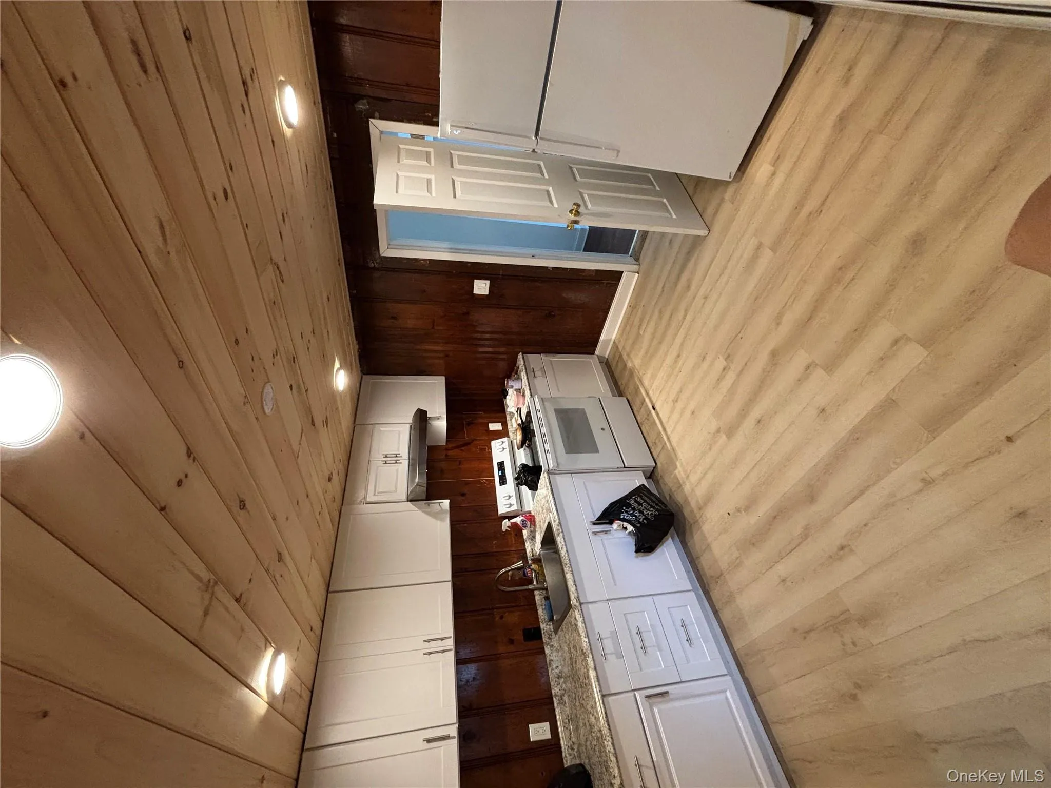 Kitchen featuring refrigerator, wood ceiling, light wood-style flooring, wood walls, and range Kitchen featuring refrigerator, wood ceiling, light wood-style flooring, wood walls, and range