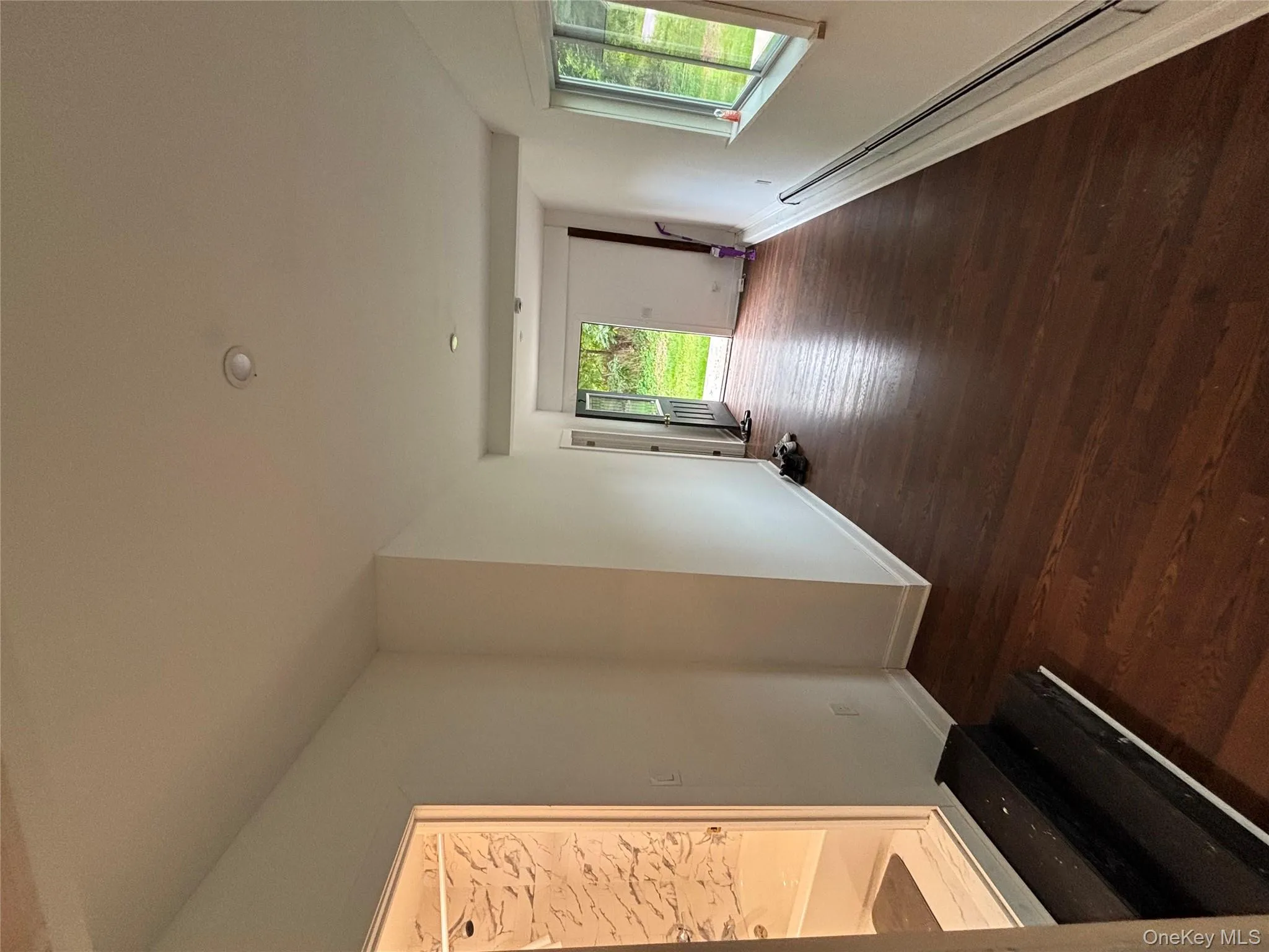 Hall with dark wood-style floors and baseboard heating Hall with dark wood-style floors and baseboard heating