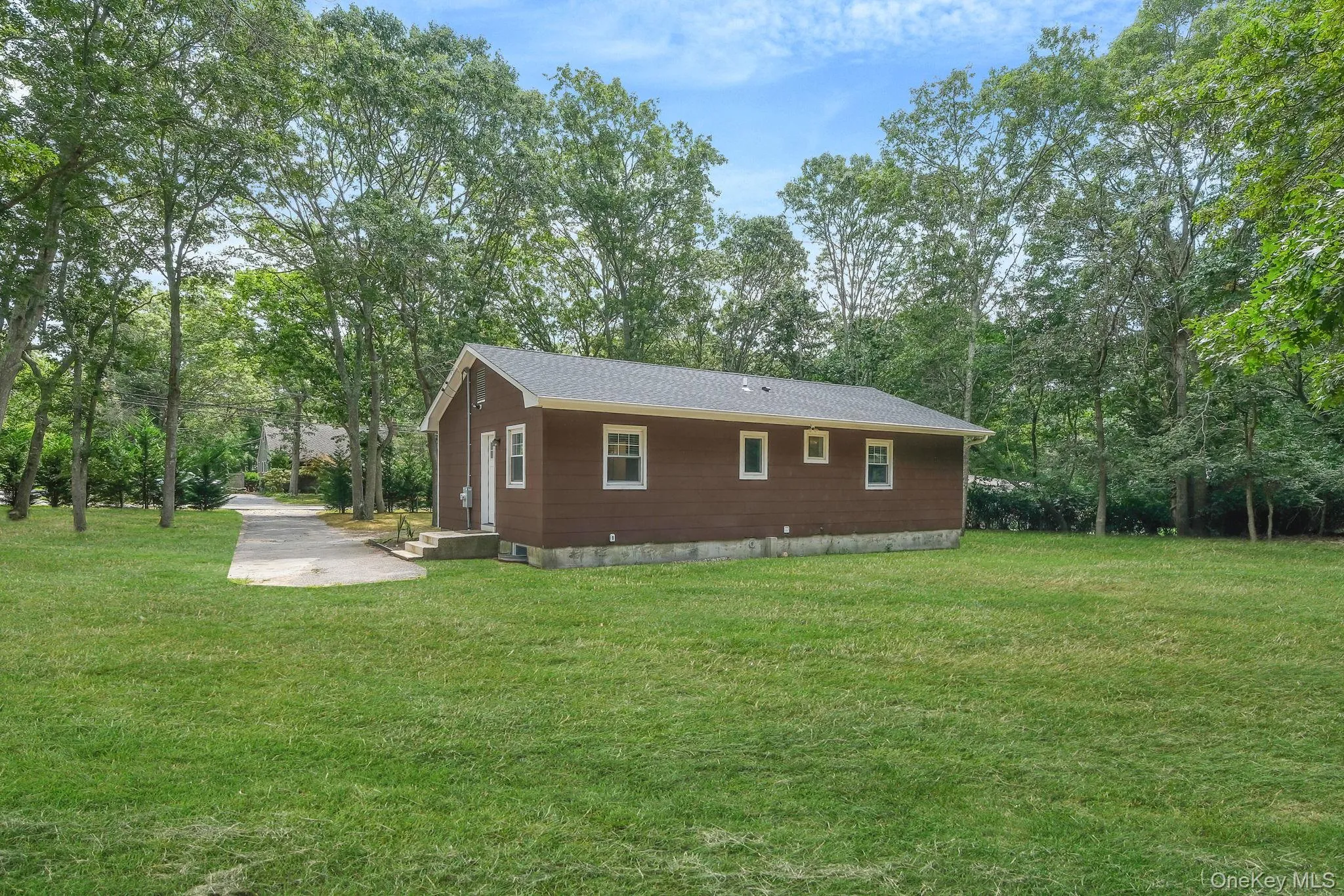 View of home's exterior featuring a lawn and view of scattered trees