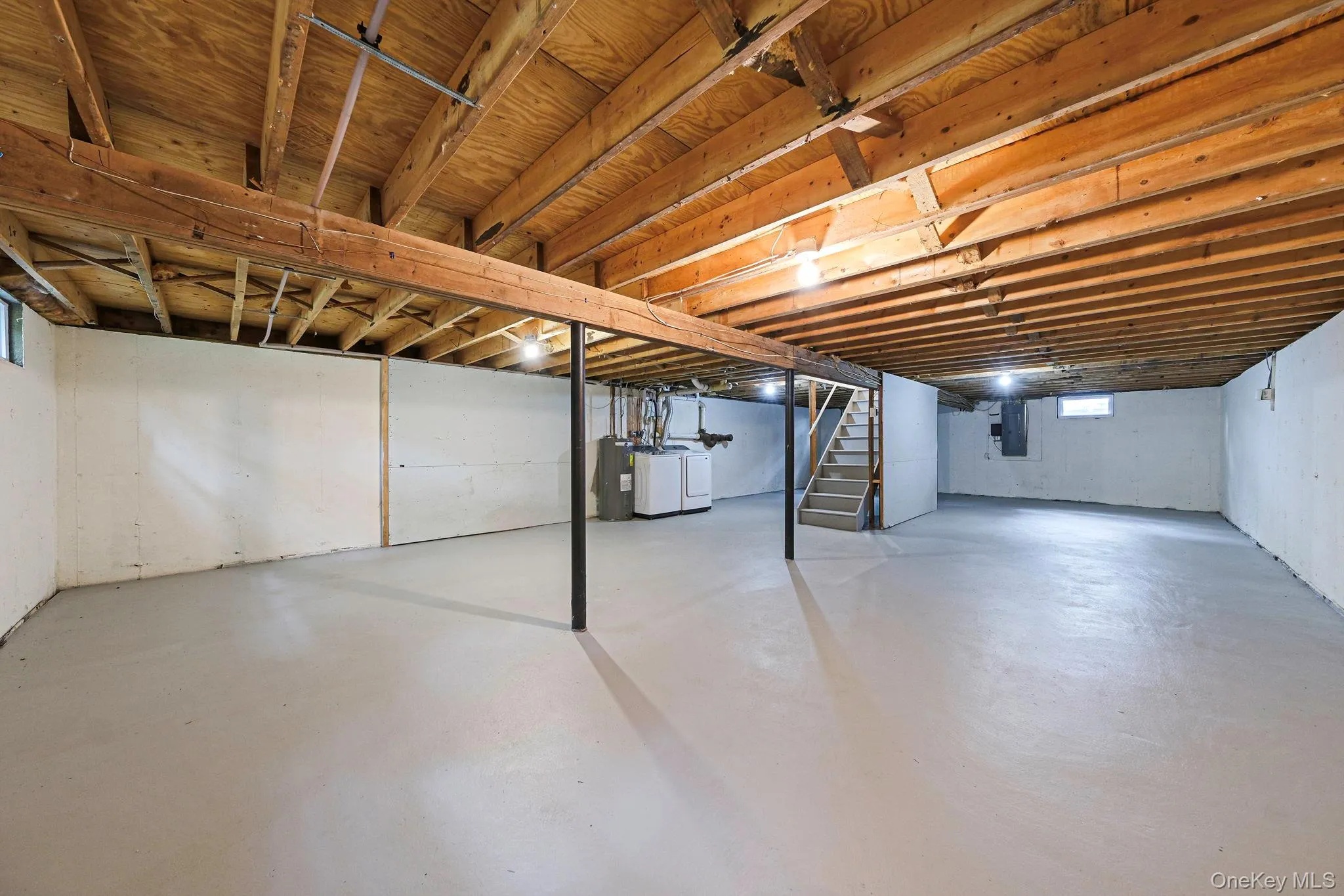 Below grade area featuring stairway, washer and dryer, and electric panel