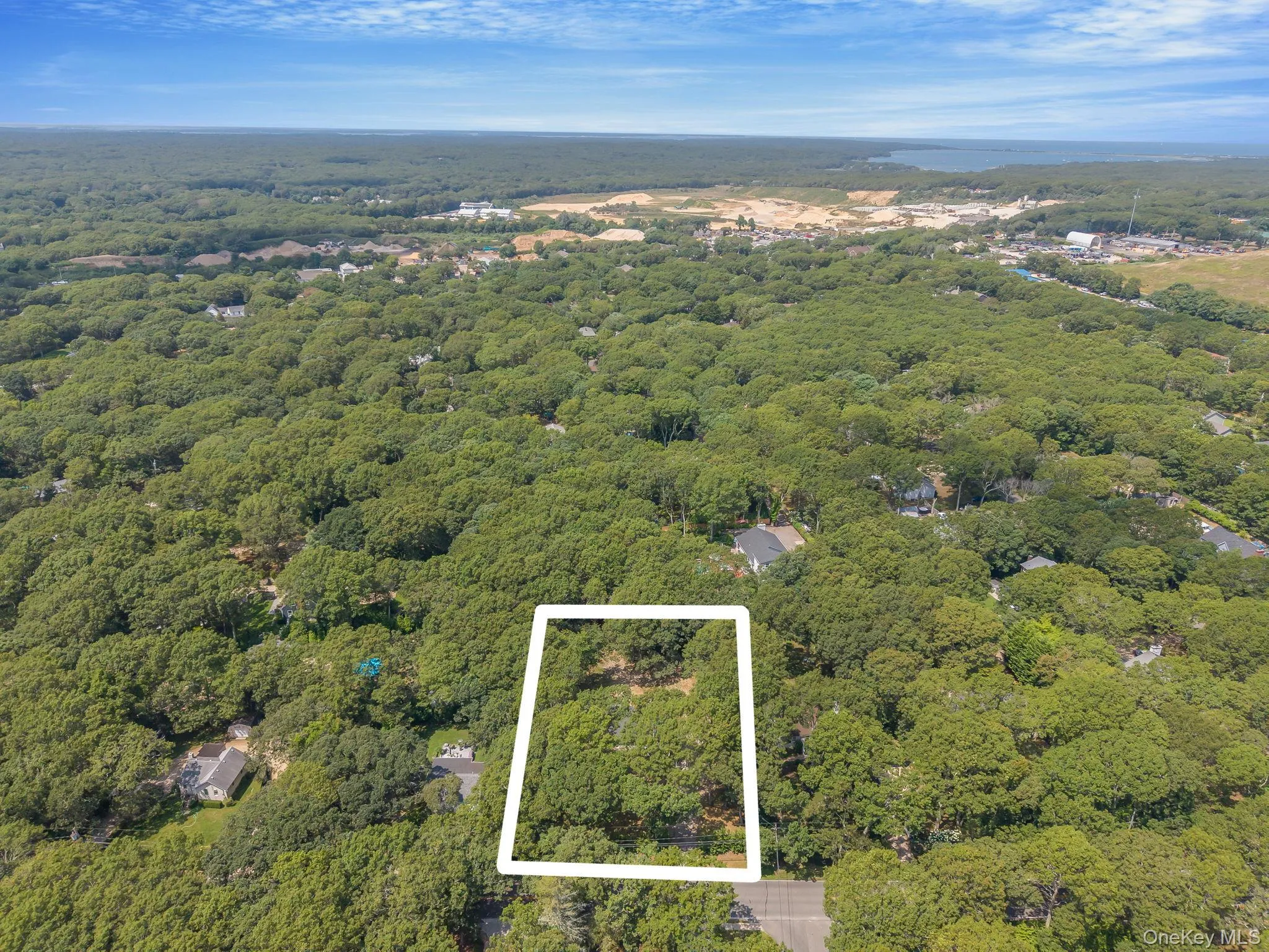 Aerial view of property and surrounding area featuring property boundaries highlighted and a large body of water