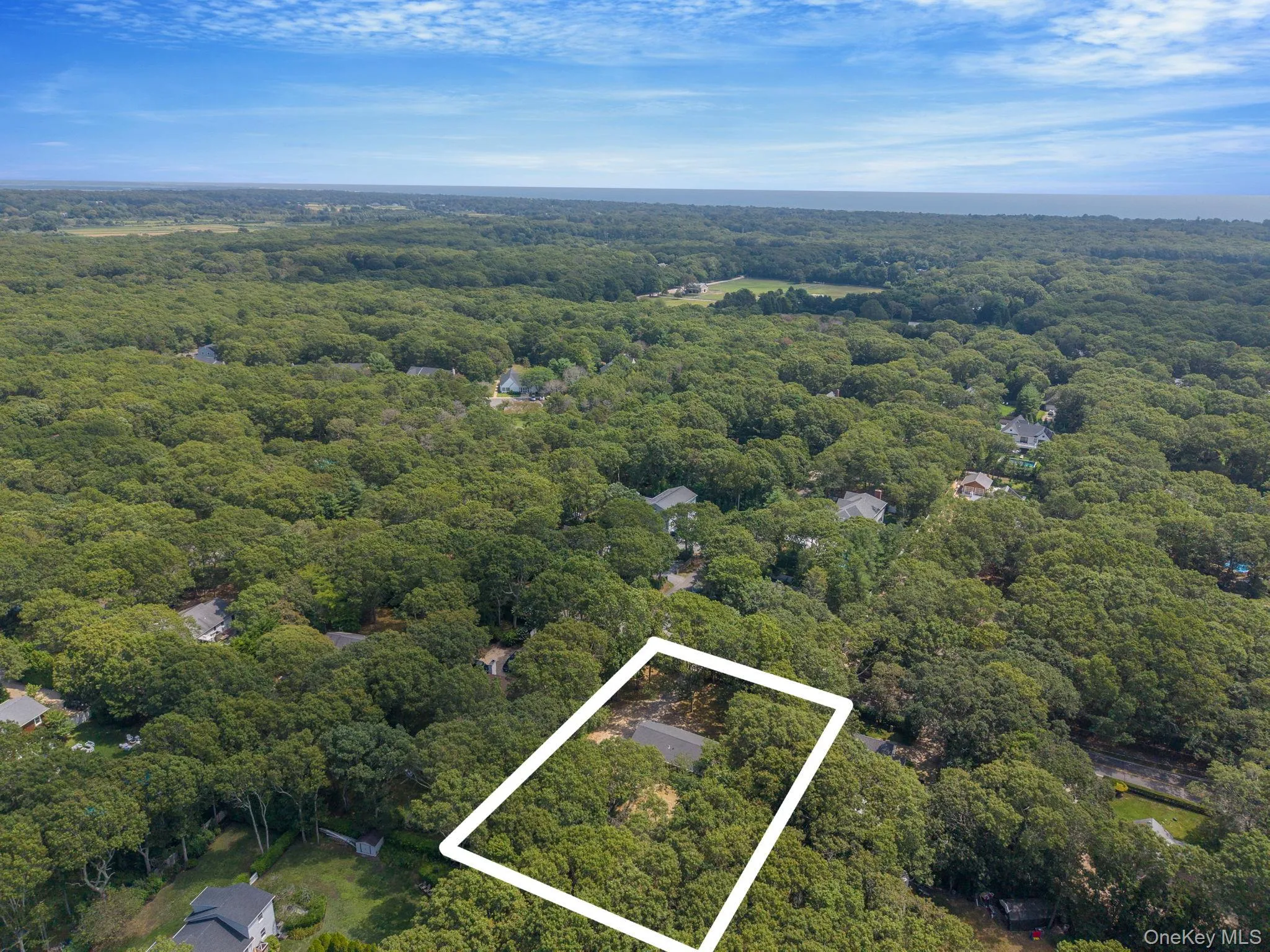 Aerial overview of property's location featuring property parcel outlined and a large body of water