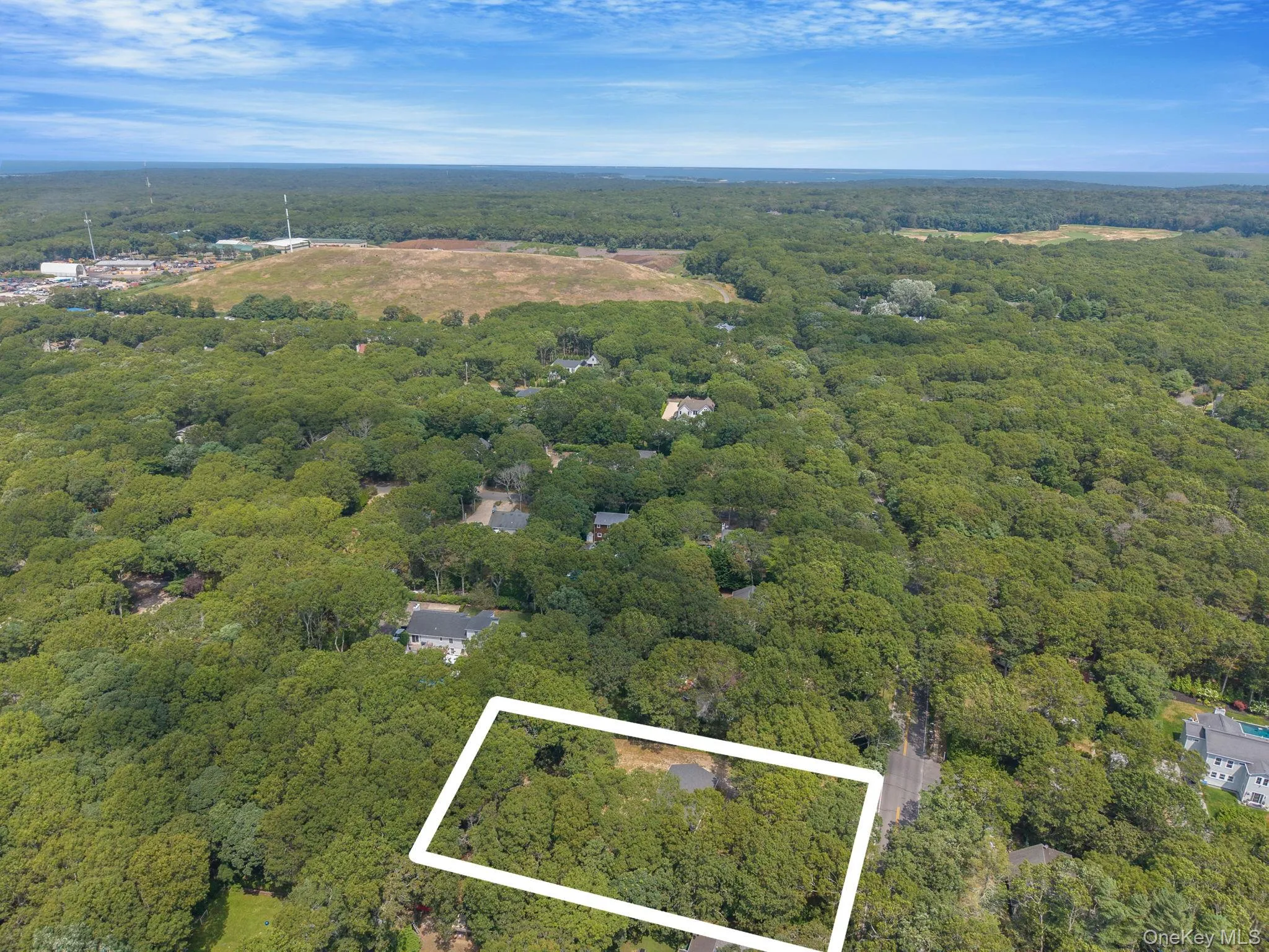 View of property location featuring a heavily wooded area and property parcel outlined
