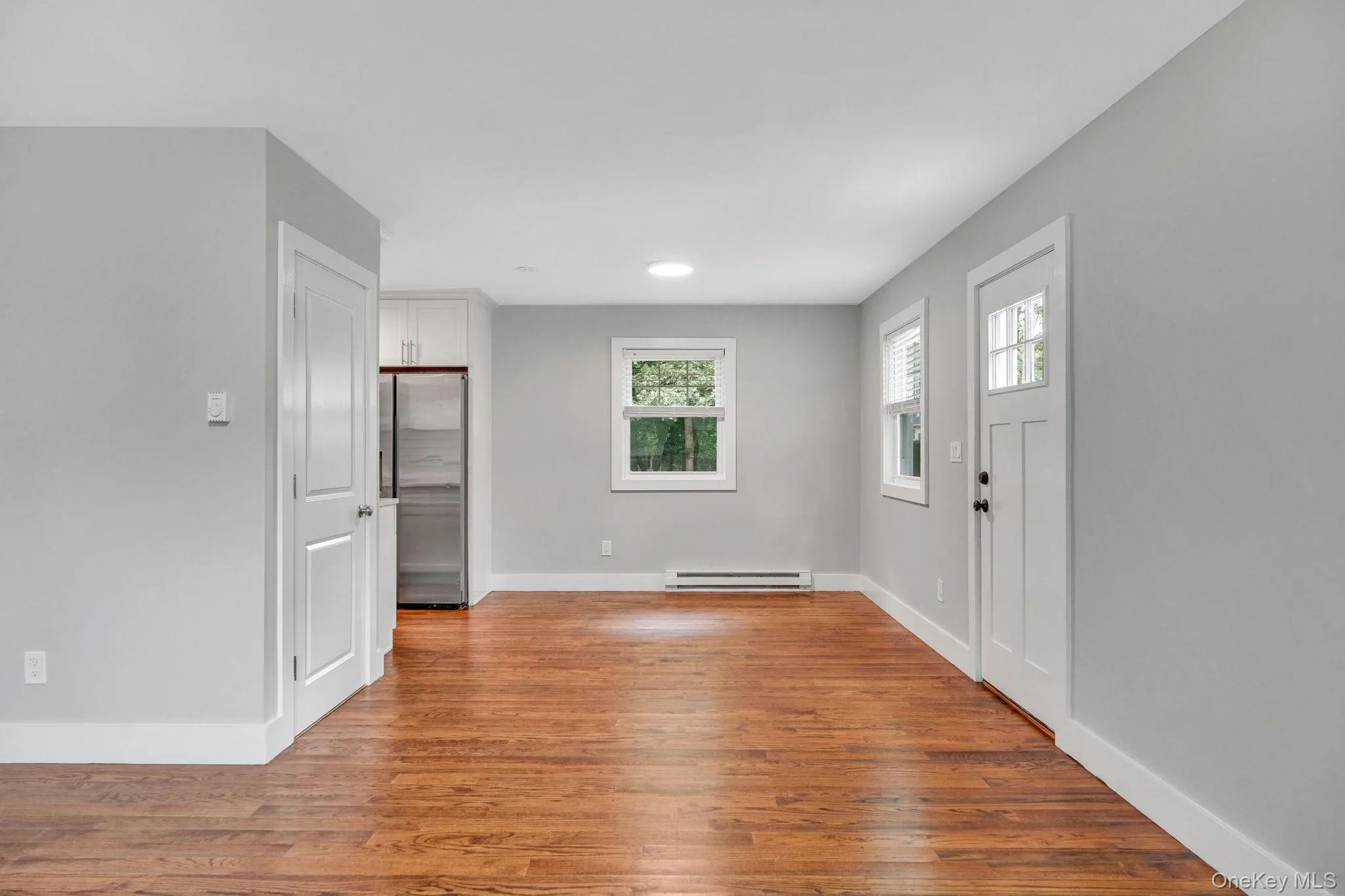Entryway with light wood-style floors and a baseboard heating unit