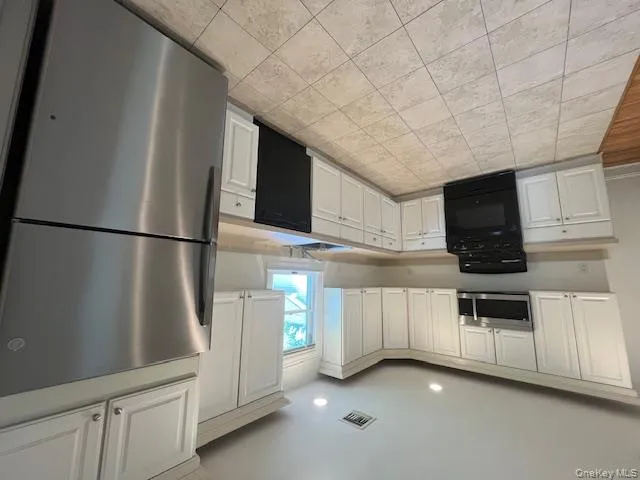Kitchen with stainless steel appliances, white cabinetry, light countertops, recessed lighting, and light tile patterned floors Kitchen with stainless steel appliances, white cabinetry, light countertops, recessed lighting, and light tile patterned floors