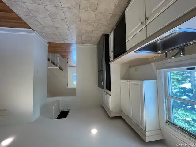 Kitchen with white cabinets, light countertops, light tile patterned floors, refrigerator, and dishwasher Kitchen with white cabinets, light countertops, light tile patterned floors, refrigerator, and dishwasher
