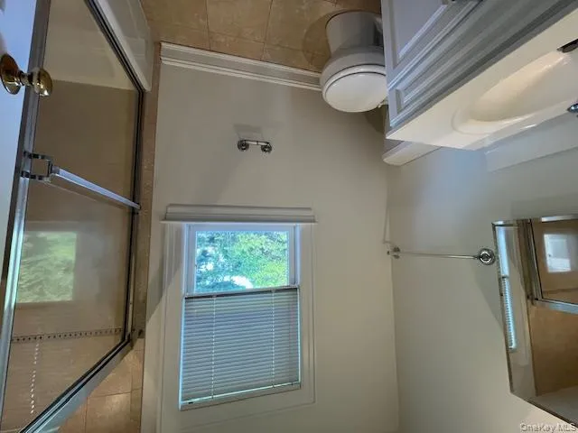 Bathroom with vanity, shower / bath combination with glass door, and light tile patterned floors Bathroom with vanity, shower / bath combination with glass door, and light tile patterned floors