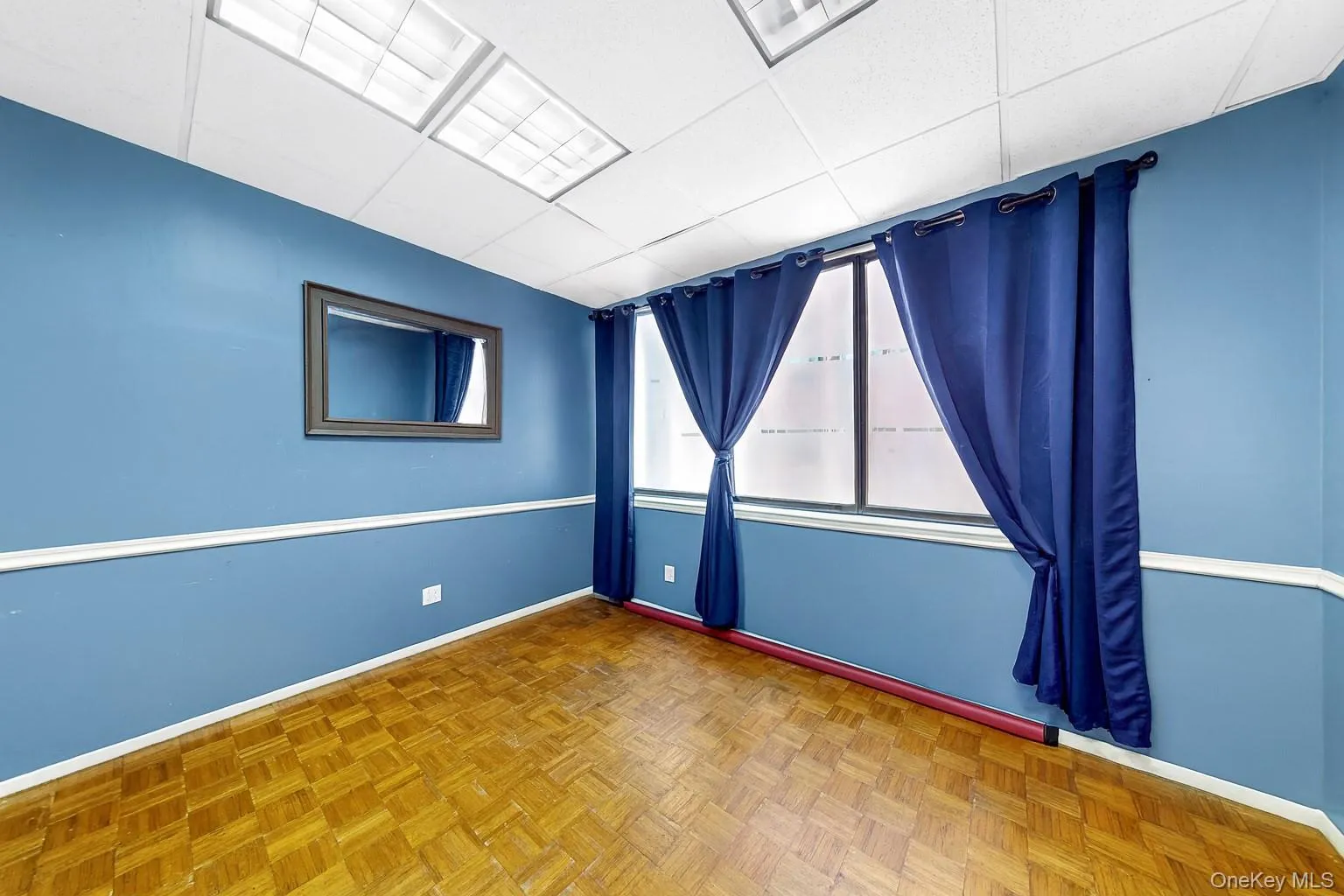 Empty room featuring a drop ceiling and baseboards Empty room featuring a drop ceiling and baseboards
