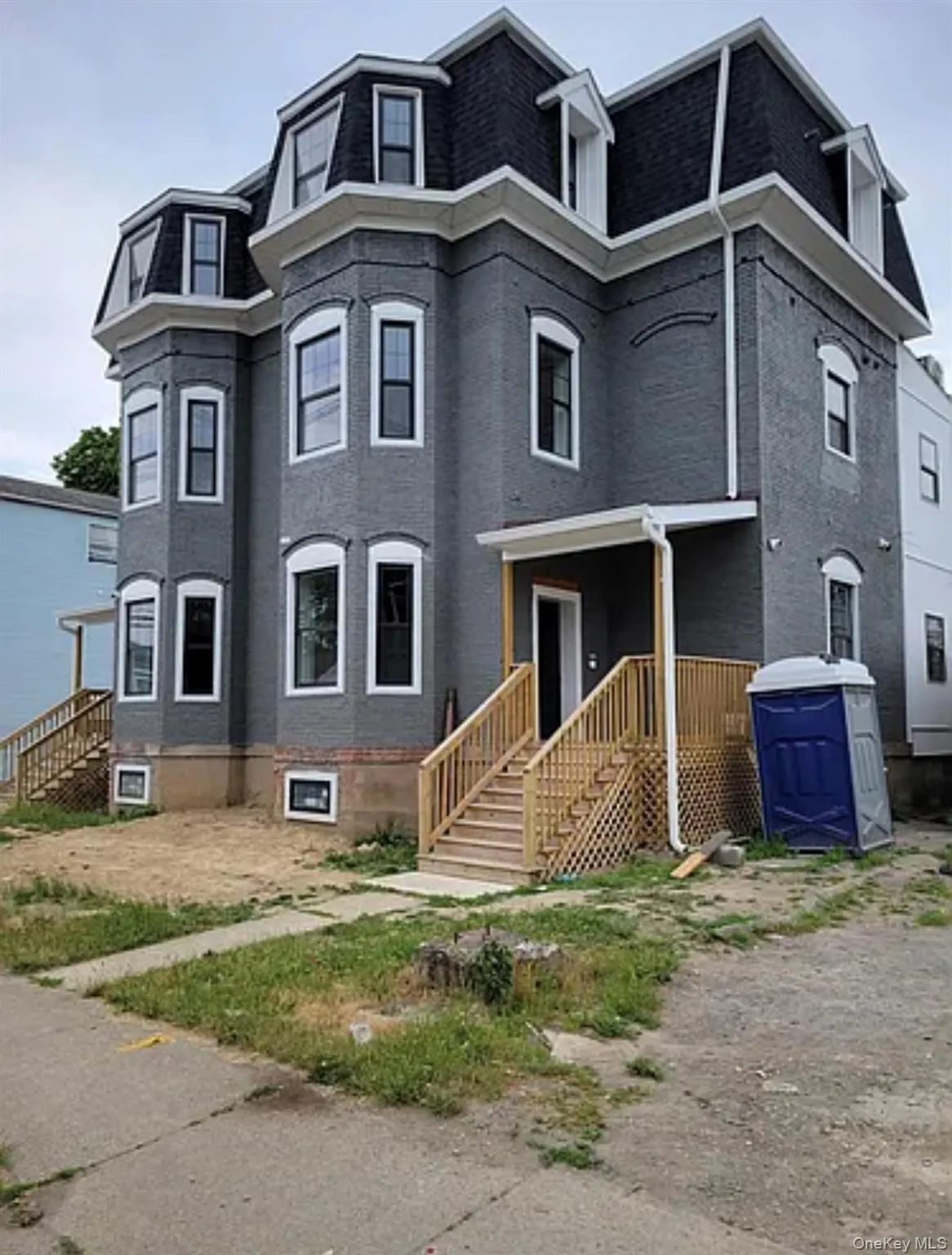 View of front of home with mansard roof, roof with shingles, and a porch View of front of home with mansard roof, roof with shingles, and a porch
