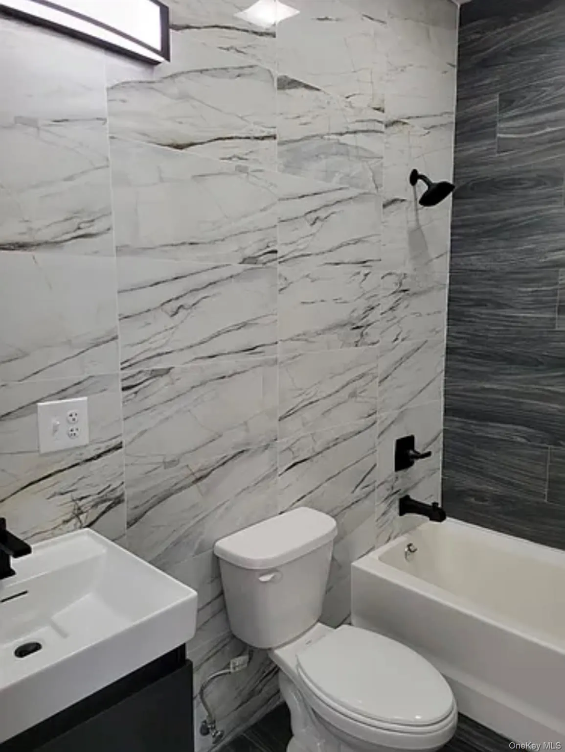 Full bathroom with shower / washtub combination, vanity, and tile walls Full bathroom with shower / washtub combination, vanity, and tile walls