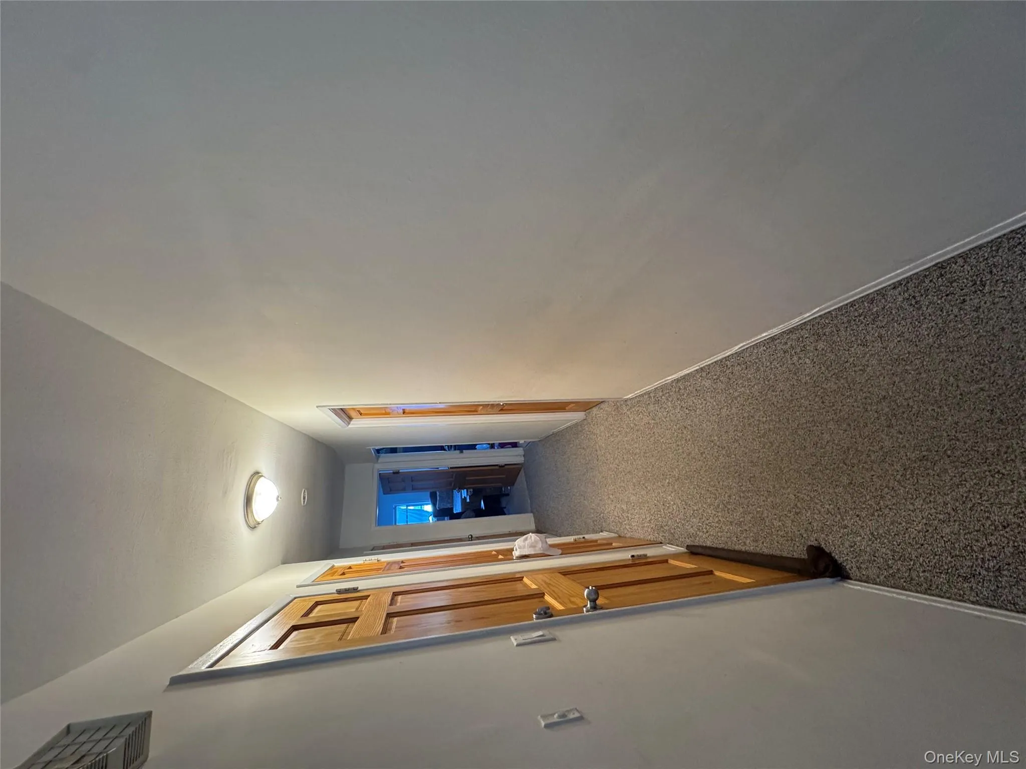 Corridor featuring dark colored carpet and baseboards Corridor featuring dark colored carpet and baseboards