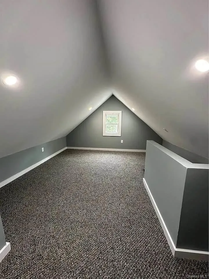 Additional living space featuring carpet and lofted ceiling Additional living space featuring carpet and lofted ceiling