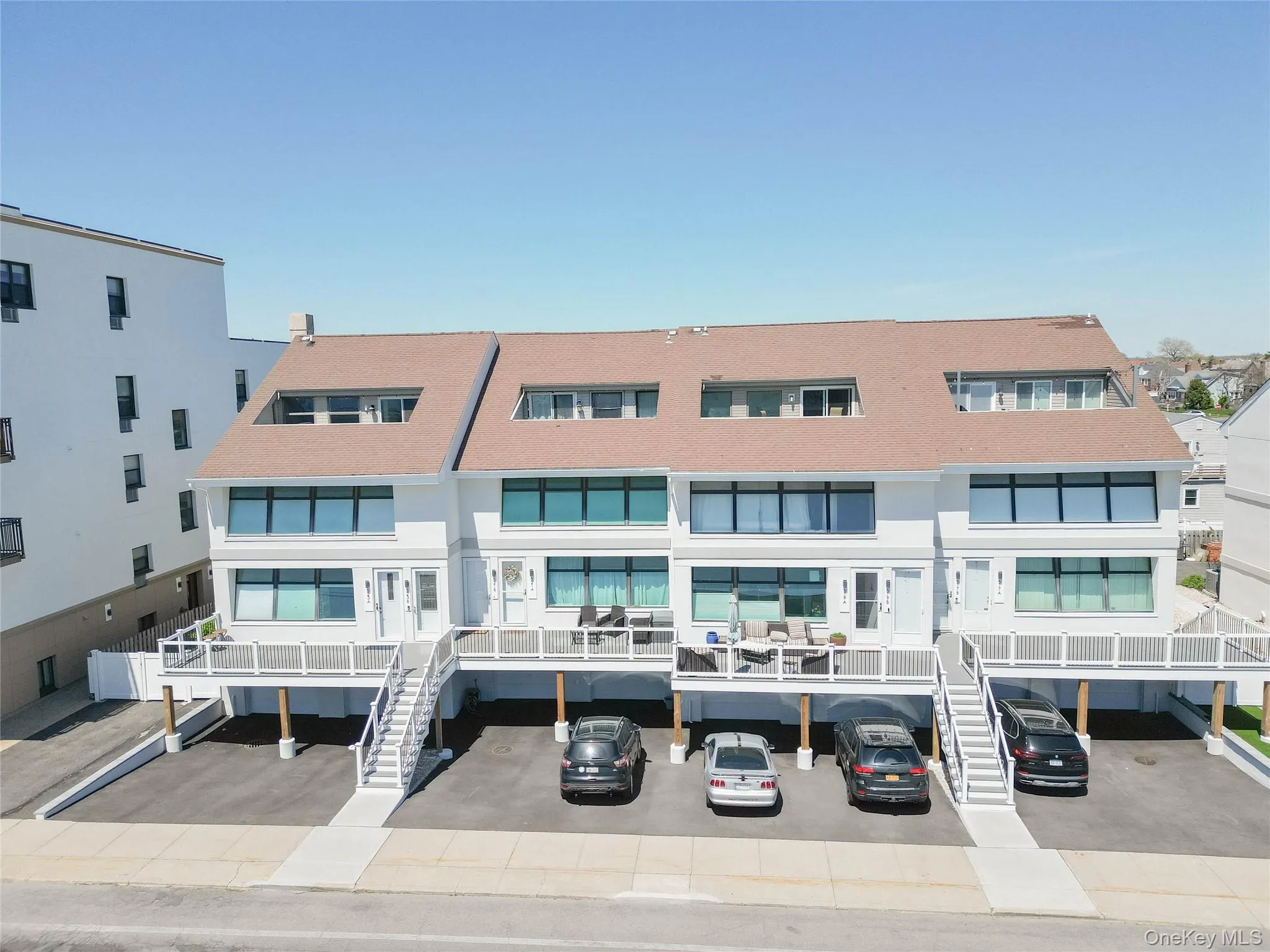 View of property with covered parking and stairway View of property with covered parking and stairway