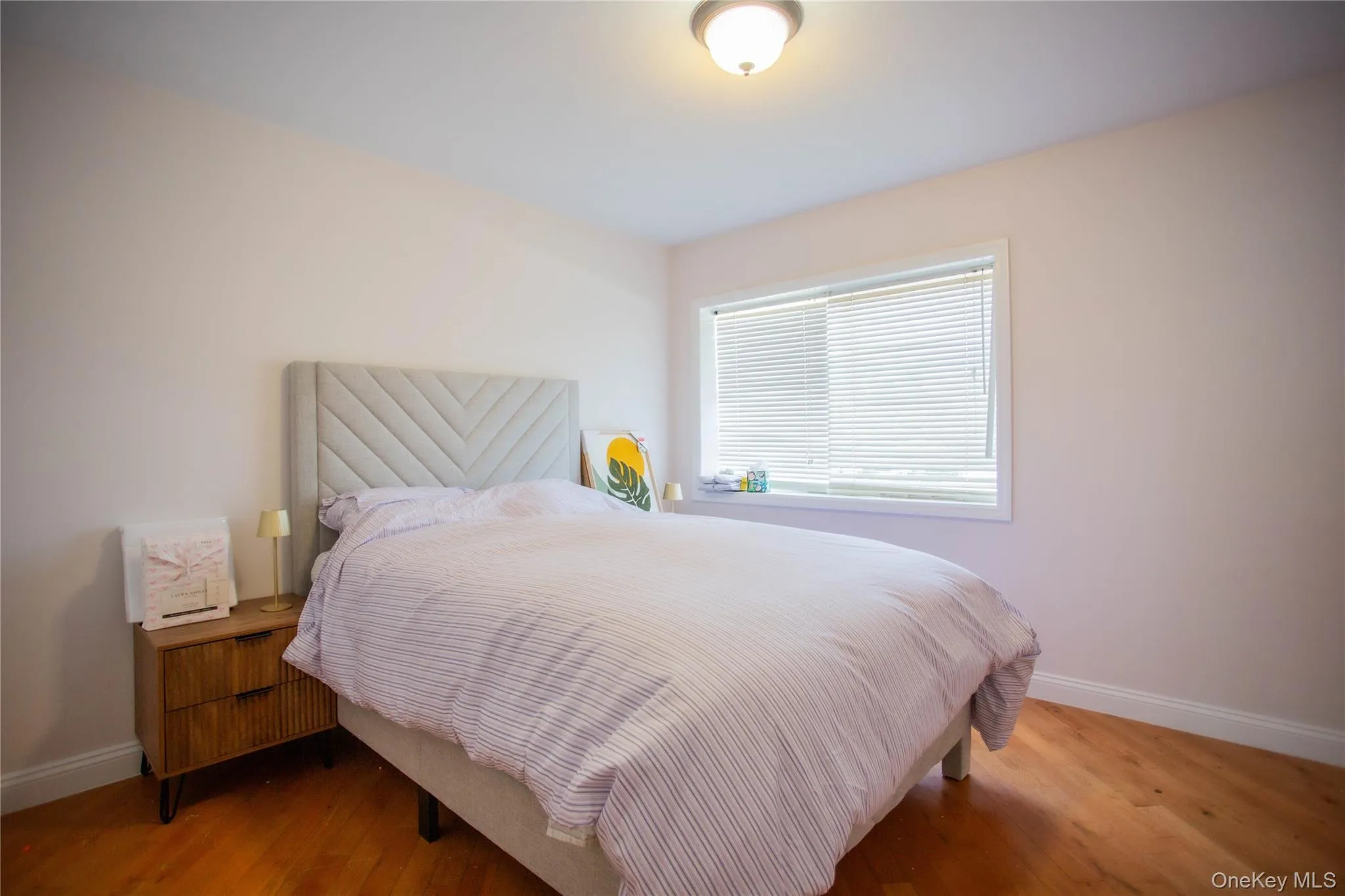 Bedroom featuring baseboards and wood finished floors Bedroom featuring baseboards and wood finished floors