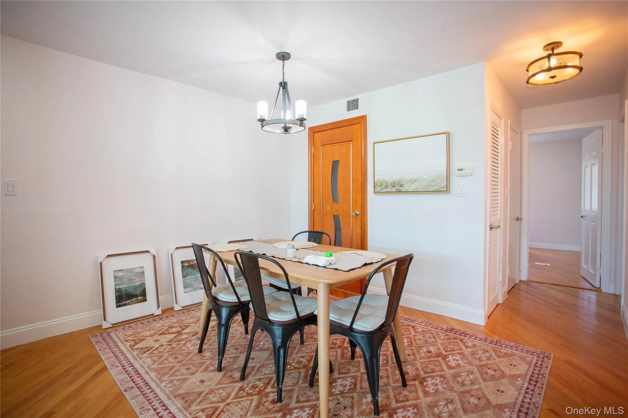 Dining area featuring light wood-style flooring and a chandelier Dining area featuring light wood-style flooring and a chandelier