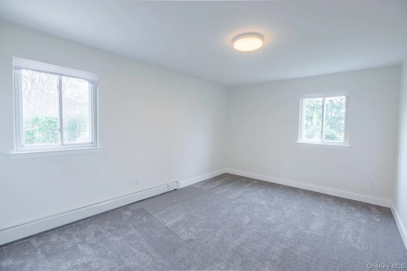 Spare room featuring baseboard heating and carpet Spare room featuring baseboard heating and carpet